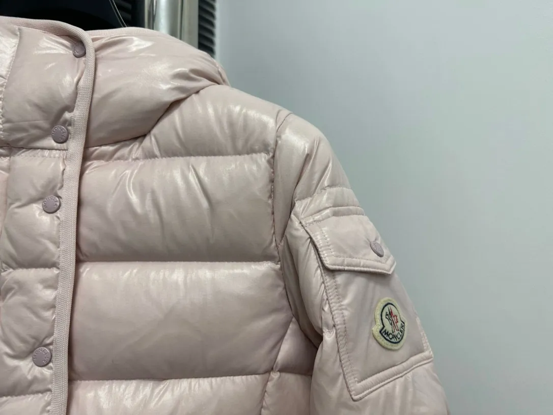 P860 [Moncler] Hooded, waisted women's short down jacket. The barante down jacket is made of glossy nylon fabric and is inspired by the 1970s. It adopts a waist design and presents an A-line silhouette, highlighting a feminine style. An adjustable hood and signature logo patch add finishing touches. Details · Made of lon laqué fabric · lon laqué lining · Filled with down · Adjustable hood · Zipper and snap closure · Suit pocket · Adjustable cuffs Size: 0/1/2/3