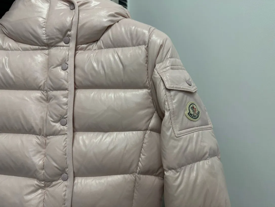 P860 [Moncler] Hooded, waisted women's short down jacket. The barante down jacket is made of glossy nylon fabric and is inspired by the 1970s. It adopts a waist design and presents an A-line silhouette, highlighting a feminine style. An adjustable hood and signature logo patch add finishing touches. Details · Made of lon laqué fabric · lon laqué lining · Filled with down · Adjustable hood · Zipper and snap closure · Suit pocket · Adjustable cuffs Size: 0/1/2/3