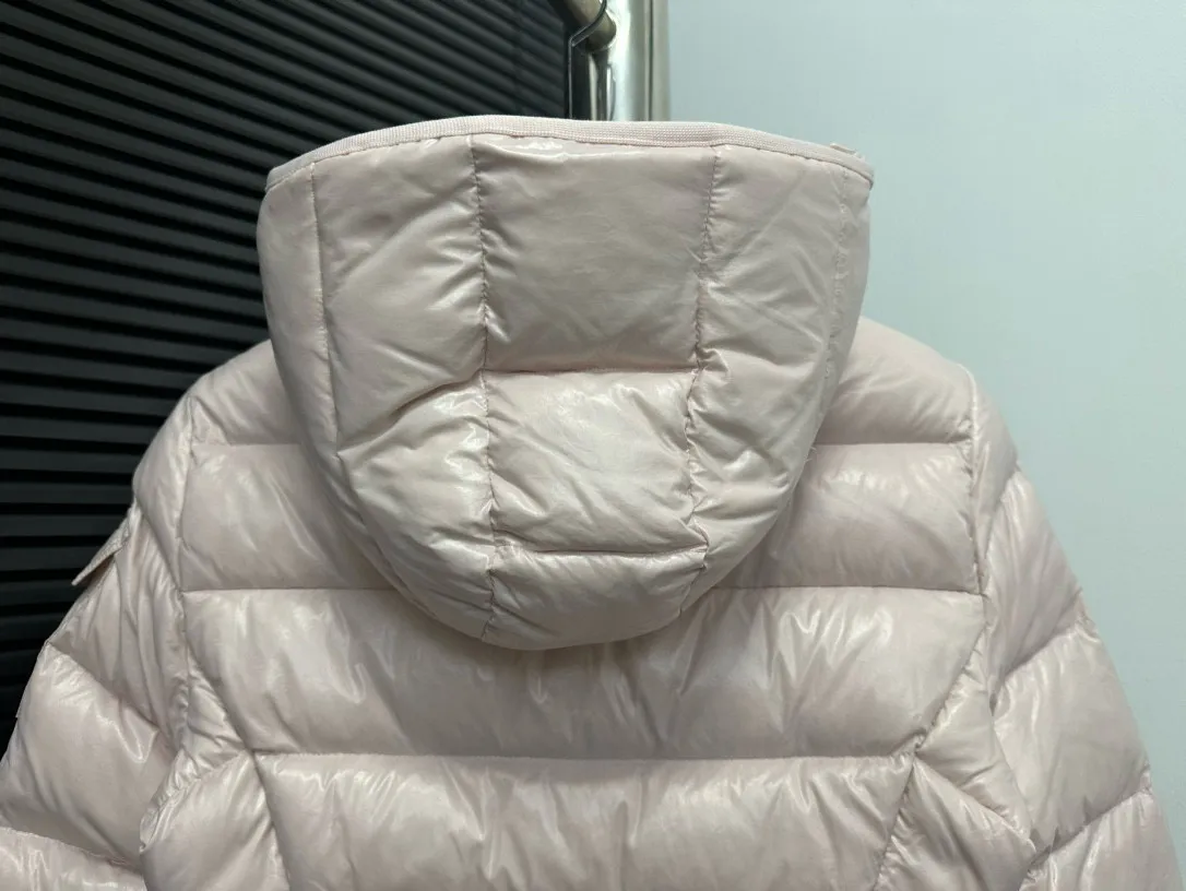 P860 [Moncler] Hooded, waisted women's short down jacket. The barante down jacket is made of glossy nylon fabric and is inspired by the 1970s. It adopts a waist design and presents an A-line silhouette, highlighting a feminine style. An adjustable hood and signature logo patch add finishing touches. Details · Made of lon laqué fabric · lon laqué lining · Filled with down · Adjustable hood · Zipper and snap closure · Suit pocket · Adjustable cuffs Size: 0/1/2/3