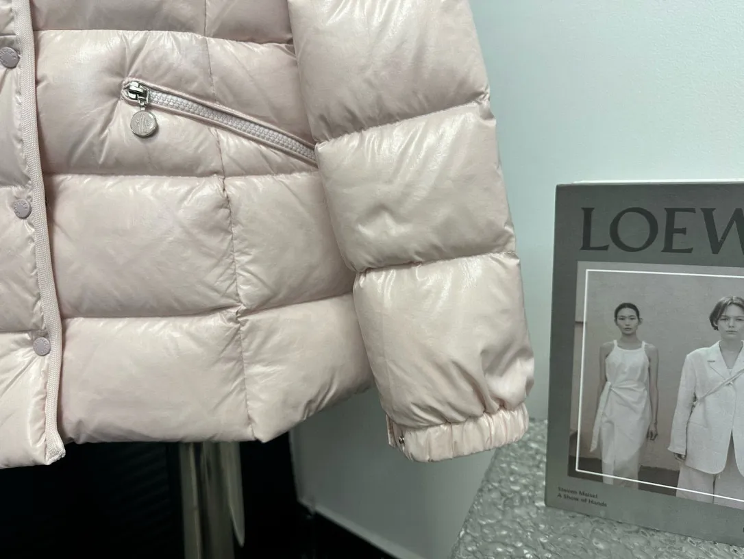 P860 [Moncler] Hooded, waisted women's short down jacket. The barante down jacket is made of glossy nylon fabric and is inspired by the 1970s. It adopts a waist design and presents an A-line silhouette, highlighting a feminine style. An adjustable hood and signature logo patch add finishing touches. Details · Made of lon laqué fabric · lon laqué lining · Filled with down · Adjustable hood · Zipper and snap closure · Suit pocket · Adjustable cuffs Size: 0/1/2/3