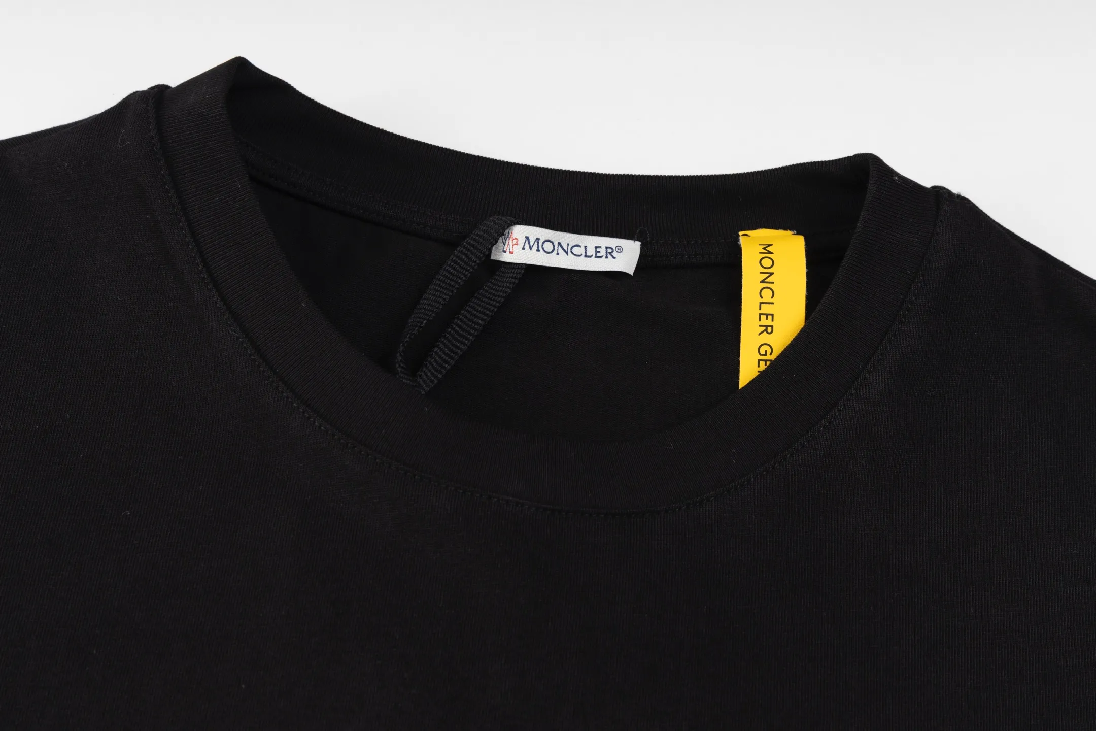 P230 exclusive supply] Moncler Hiroshi Fujiwara co-branded short-sleeve (black) is made of double-ply cotton plain fabric. The warp and weft yarns are interwoven one up and down to form a uniform grid-like texture, with a tight but light structure. Cotton fiber has natural breathability and skin-friendly properties. Combined with the pore structure of plain weave, it is suitable for daily perspiration needs and has good wearing comfort. The yarn has many intertwining points, which strengthens the tear resistance and can maintain its shape after multiple washings. Four high-saturation patterns are presented on the fabric through glue printing. The scraper pressure is even and the scraping is performed in three steps to ensure that the glue is fully penetrated and covered. After curing at high temperature, the pigment is firmly bonded to the cotton fiber. The ink-absorbing and penetrating properties of the cotton fiber make the pattern less likely to fall off due to friction. By actively interfering with the shrinkage potential of cotton fibers, the fabric is able to transition from changeable to stable, improving dimensional stability while being less prone to deformation and wrinkles. Size:S-M-L-XL