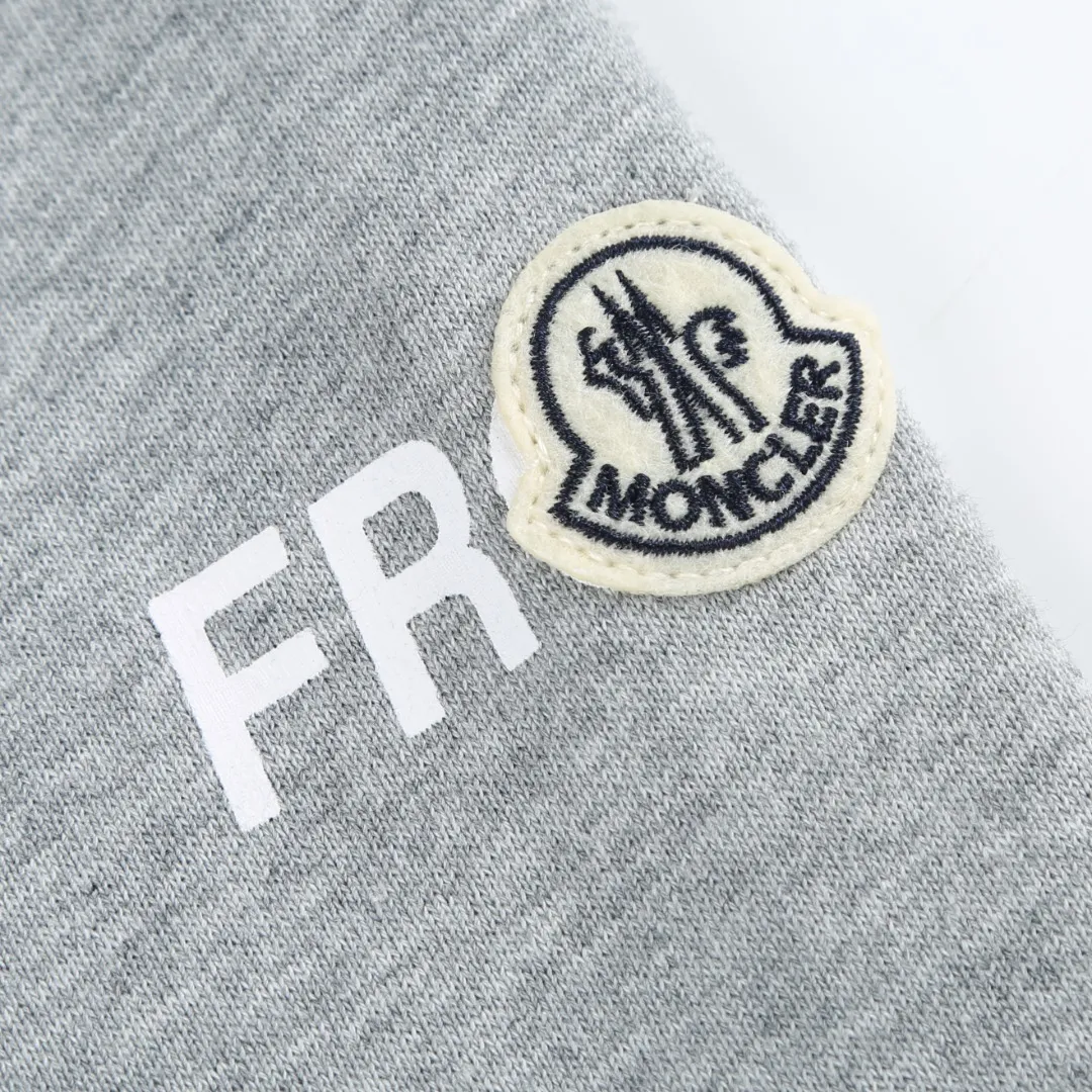 P370 MONCLER printed round neck sweatshirt Fabric selection: Single-sided fish scale fabric woven with cotton as the base. The front is a smooth knitted surface, and the skin-touching surface is formed into three-dimensional terry through the floating thread knitting technology of the knitting machine, which increases the fluffiness and has a delicate touch. The terry structure absorbs a large amount of water and evaporates quickly, so it is not easy to loosen and deform after repeated washing.  Process 1: Use glue printing to present 4 high-saturation patterns on the fabric. The pressure of the scraper is even, and the scraping printing is done in 3 times to ensure that the glue is fully penetrated and covered. After curing at high temperature, the pigment is firmly bonded to the cotton fiber. The ink-absorbing and penetrating properties of the cotton fiber make the pattern less likely to fall off due to friction.  Process 2: The 2*2 rib formed by alternating longitudinal rows of front coils and longitudinal rows of back coils is still very elastic and has a wide pattern that fits the wrist and waist without a sense of restraint. The gaps between the coils allow air to circulate without losing warmth.  Process 2: By actively interfering with the shrinkage potential of cotton fibers, the fabric is able to transition from changeable to stable, improving dimensional stability while being less prone to deformation and wrinkles.  Accessories: One to one customized 3-standard SIZE: S M L XL