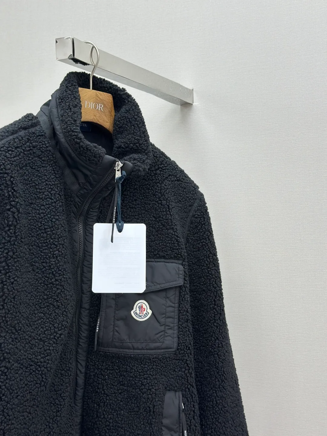 P620 MONCLER Emblem Suede Jacket Fabric Selection: Made from 100% polyester fiber, shearling fabric is woven through high-tech processing. The surface has a layer of fine, dense velvet, which feels very smooth when in contact with the skin and has good skin-friendliness. The suede surface can hold a layer of still air in place, forming a good thermal insulation layer and providing excellent warmth retention. Due to the hollow nature of the fiber, although it is warm, it does not hinder the overall lightness of the quality. Details: The neckline, front placket, side pockets, and chest patch pockets are all embellished with nylon fabrics of the same color, creating a visual sense of hierarchy. Decorated with elastic cuffs and hem, it balances practicality and beauty. Accessories: Customized zipper pendant Customized badge Customized pocket snap SIZE: S M L XL