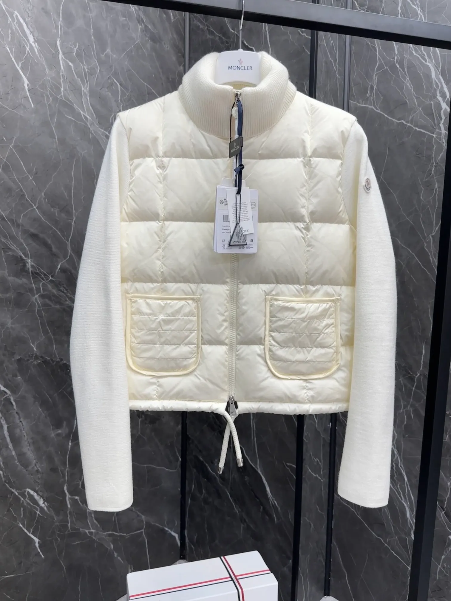 P600 New in Down ⬆️Moncler women’s padded wool zipper cardigan. This women’s wool cardigan is filled with down and can be styled in a variety of ways depending on the weather. (⚠️ Made of real wool, it will be slightly prickly when worn close to the body. It is recommended to match it with an inner layer. Fairies who are more concerned about it should not place an order.) This cardigan is made of wool and is filled with down on the front, back and collar. Lightweight knitted piece with a high collar and zip style. Details •Made from fine merino wool •Longue saison lining •Down filling at front, back and collar •Punto Milano stitching •14 stitches •Zip closure •Patch pockets •Drawstring hem Size: 1-4 Off-White Black L258031