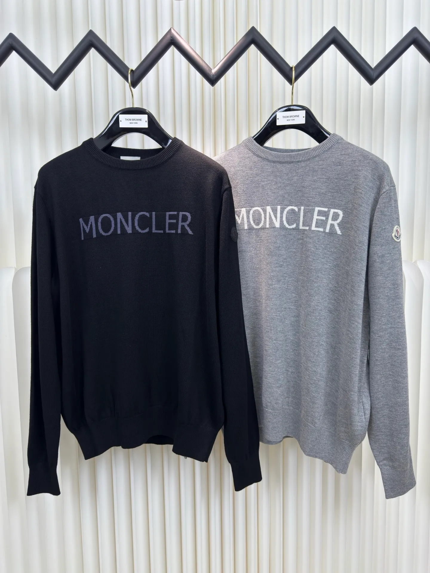 P440 MONCLER jacquard crew neck sweater is made of wool blended fabric, mainly 95% wool, combined with 4% nylon and 1% spandex. The main body of wool ensures the warmth and comfort of the clothing. The addition of a small amount of nylon and spandex significantly improves the elasticity and wear resistance. The ribbed decorative parts are made of 100% wool, which further enhances the overall texture.  Through the high needle count and fine gauge loom, combined with the orderly direction of the internal yarn, the floating threads are cleverly woven and stored, with almost no unnecessary thread mess. The color switching of each group of letters is synchronized with the knitting needles in milliseconds, forming a delicate letter LOGO jacquard decoration on the chest. Size S M L XL