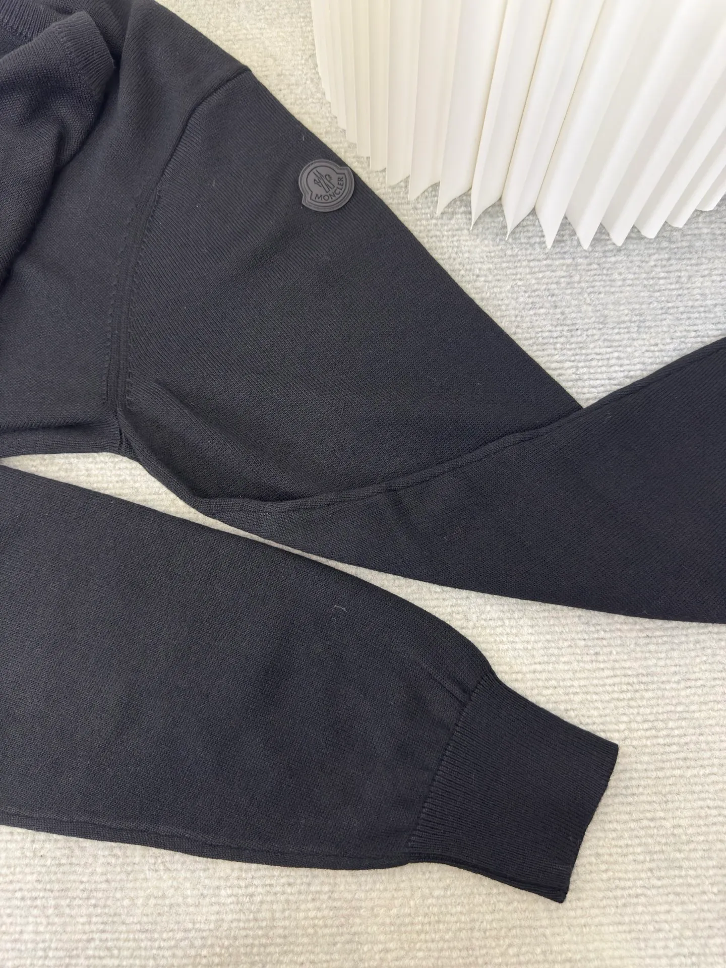 P440 MONCLER jacquard crew neck sweater is made of wool blended fabric, mainly 95% wool, combined with 4% nylon and 1% spandex. The main body of wool ensures the warmth and comfort of the clothing. The addition of a small amount of nylon and spandex significantly improves the elasticity and wear resistance. The ribbed decorative parts are made of 100% wool, which further enhances the overall texture.  Through the high needle count and fine gauge loom, combined with the orderly direction of the internal yarn, the floating threads are cleverly woven and stored, with almost no unnecessary thread mess. The color switching of each group of letters is synchronized with the knitting needles in milliseconds, forming a delicate letter LOGO jacquard decoration on the chest. Size S M L XL