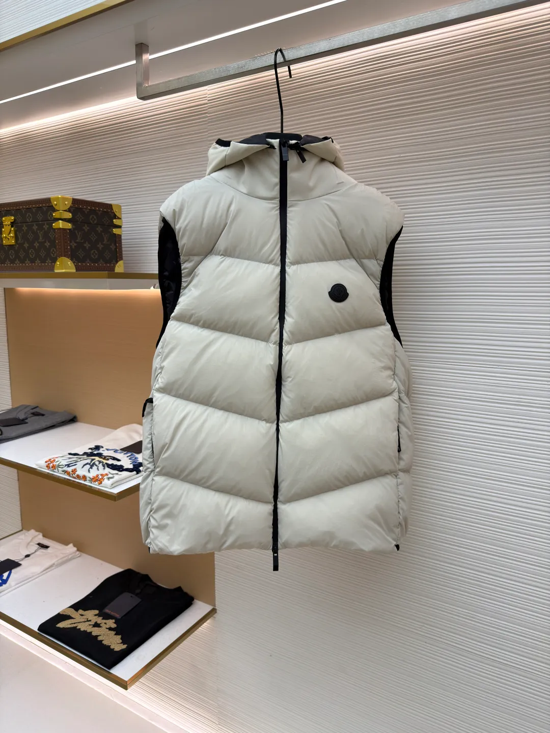 P670 MONCLER emblem hooded down vest ●Original version: purchased and developed at 7899 ●Item number: 1681646-C00 ●Fabric: white duck down fabric ●Technology: mechanical down filling ●Color: white ●Version: fitted version ●Weight: about 550 grams ●Size: 1-2-3-4 ●Description: The nylon fabric made of 100% nylon is woven into a tight and tough fabric through advanced textile technology. The strength of the frame is increased to effectively block the invasion of cold wind and lock the warm air generated by the down layer. After a tight weaving process and special treatment, it is waterproof and windproof. The surface forms a certain lotus leaf effect. It is also wrinkle-resistant and not easy to deform, making it easy for daily care. The quilting stitches are sewn in a diagonal direction at an angle of about 70 degrees, and the diagonal lines are arranged in parallel. The fabric and filling are planned into different functional areas, and the quilting stitches in each partition are relatively independent. This allows the finished product to produce a larger deformation space along the diagonal direction when stretched and pressed, making it less likely to tighten and break, and has rich visual effects, modern and advanced features. After the hood is removed, the stand-up collar displays an embossed logo of the same color, adding a unique visual experience and tactile details. Filled with 90% selected white duck down and weighing 170g, it ensures fluffiness, quick rebound, lightness and warmth. The overall wiring is straight and delicate, the fabric is comfortable and soft, and the color is consistent without color difference. It can be matched with the same style to create a fashionable look and control various occasions. Customized accessories, complete with three standards, same style for men and women!