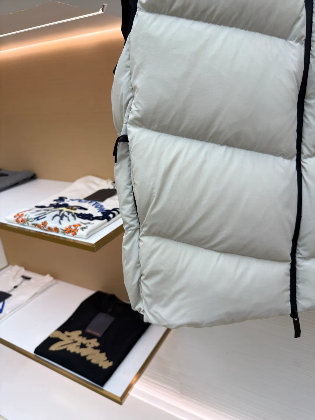 P670 MONCLER emblem hooded down vest ●Original version: purchased and developed at 7899 ●Item number: 1681646-C00 ●Fabric: white duck down fabric ●Technology: mechanical down filling ●Color: white ●Version: fitted version ●Weight: about 550 grams ●Size: 1-2-3-4 ●Description: The nylon fabric made of 100% nylon is woven into a tight and tough fabric through advanced textile technology. The strength of the frame is increased to effectively block the invasion of cold wind and lock the warm air generated by the down layer. After a tight weaving process and special treatment, it is waterproof and windproof. The surface forms a certain lotus leaf effect. It is also wrinkle-resistant and not easy to deform, making it easy for daily care. The quilting stitches are sewn in a diagonal direction at an angle of about 70 degrees, and the diagonal lines are arranged in parallel. The fabric and filling are planned into different functional areas, and the quilting stitches in each partition are relatively independent. This allows the finished product to produce a larger deformation space along the diagonal direction when stretched and pressed, making it less likely to tighten and break, and has rich visual effects, modern and advanced features. After the hood is removed, the stand-up collar displays an embossed logo of the same color, adding a unique visual experience and tactile details. Filled with 90% selected white duck down and weighing 170g, it ensures fluffiness, quick rebound, lightness and warmth. The overall wiring is straight and delicate, the fabric is comfortable and soft, and the color is consistent without color difference. It can be matched with the same style to create a fashionable look and control various occasions. Customized accessories, complete with three standards, same style for men and women!