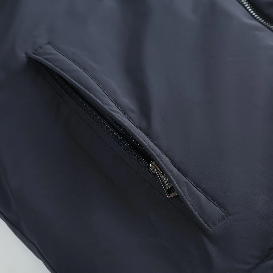 P860 MONCLER hooded jacket-style down jacket is made of 100% polyester fiber. After microfiberization treatment, the individual fibers become extremely fine, which greatly increases the fiber surface area, making the fabric soft and smooth, and the touch is close to natural fibers. The high-density textile method makes the structure tight, thus giving it a certain degree of wrinkle resistance, windproof warmth and wear resistance.  Lining selection: High-density lining fabric made of ultra-fine denier, 0.08mm thickness to avoid increasing the overall weight and making it smooth to wear. The high-density woven structure forms a wind resistance layer to protect the thermal efficiency of the thermal layer from loss. It can also withstand the expansion pressure of down and prevent deformation and damage after long-term use.  High-quality filling: 90 white duck down is selected, with a weight of 200g, ensuring excellent thermal insulation performance. After strict screening and treatment, the velvet is not easy to be drilled, ensuring durability. Details: The leather flap pocket on the chest is matched with a pebbled leather flap + matte metal buckle. It is low-key and exudes nobility. The hidden adjustment rope gives a sense of sophistication when you raise your hand. The "ID card" is directly embedded on the black satin inner patch pocket! Silver snaps + red, white and blue webbing, low-key yet exuding a sense of luxury, both visually and tactilely smooth.  Accessories: one-to-one customized buttons, one-to-one customized hem drawstring buckle, one-to-one customized phoenix eyes, one-to-one customized zipper pendant SIZE: 1 2 3 4