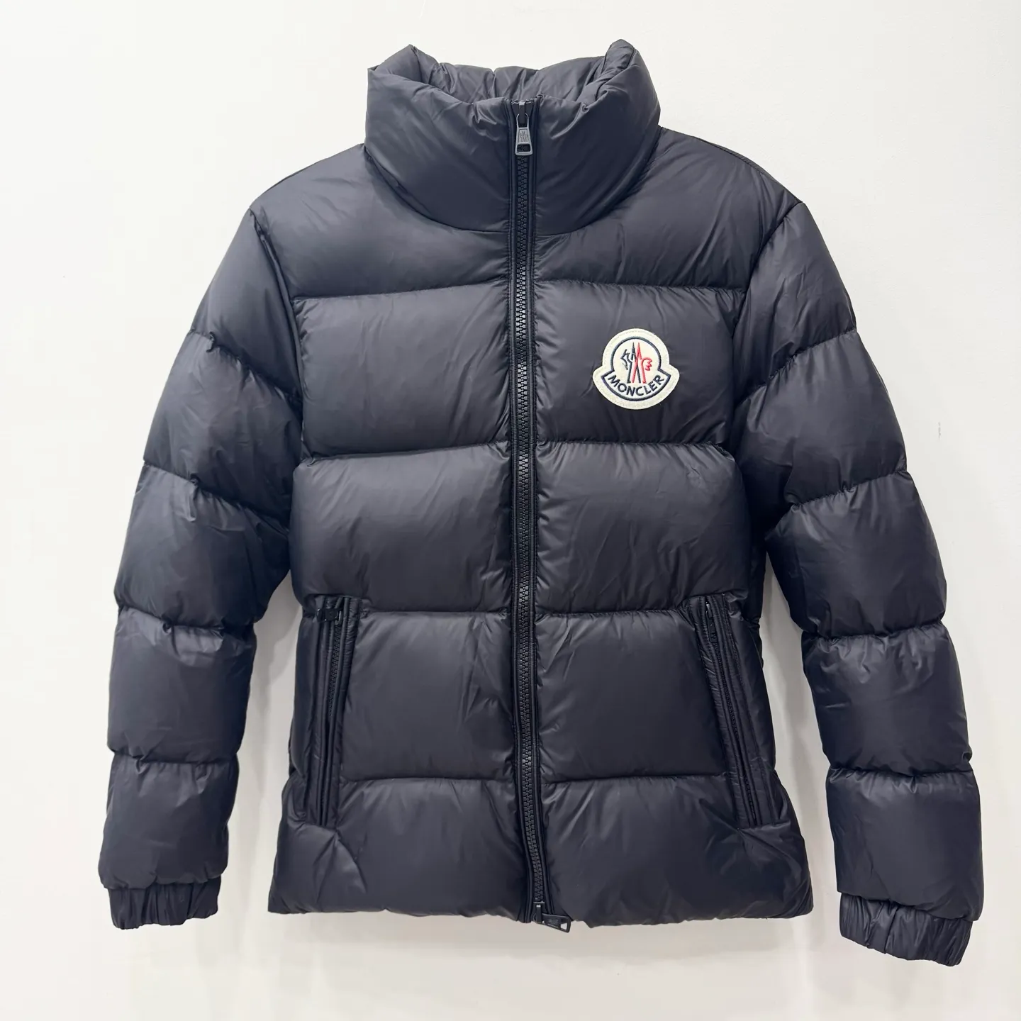 P840 Brand: MONCLER Filling: 90 white duck down Weight: 290 Size: 12345 Color: Black Blue Citala down jacket uses ultra-light nylon lining and longue saison to ensure a high degree of warmth without sacrificing lightness. The style features a comfortable fit, unique high collar and pudding quilting.   Made of ultralight nylon saison bench lining feather filling stand collar zipper closure zipper pockets elasticated cuffs and bottom of garment felt logo patch size and fit