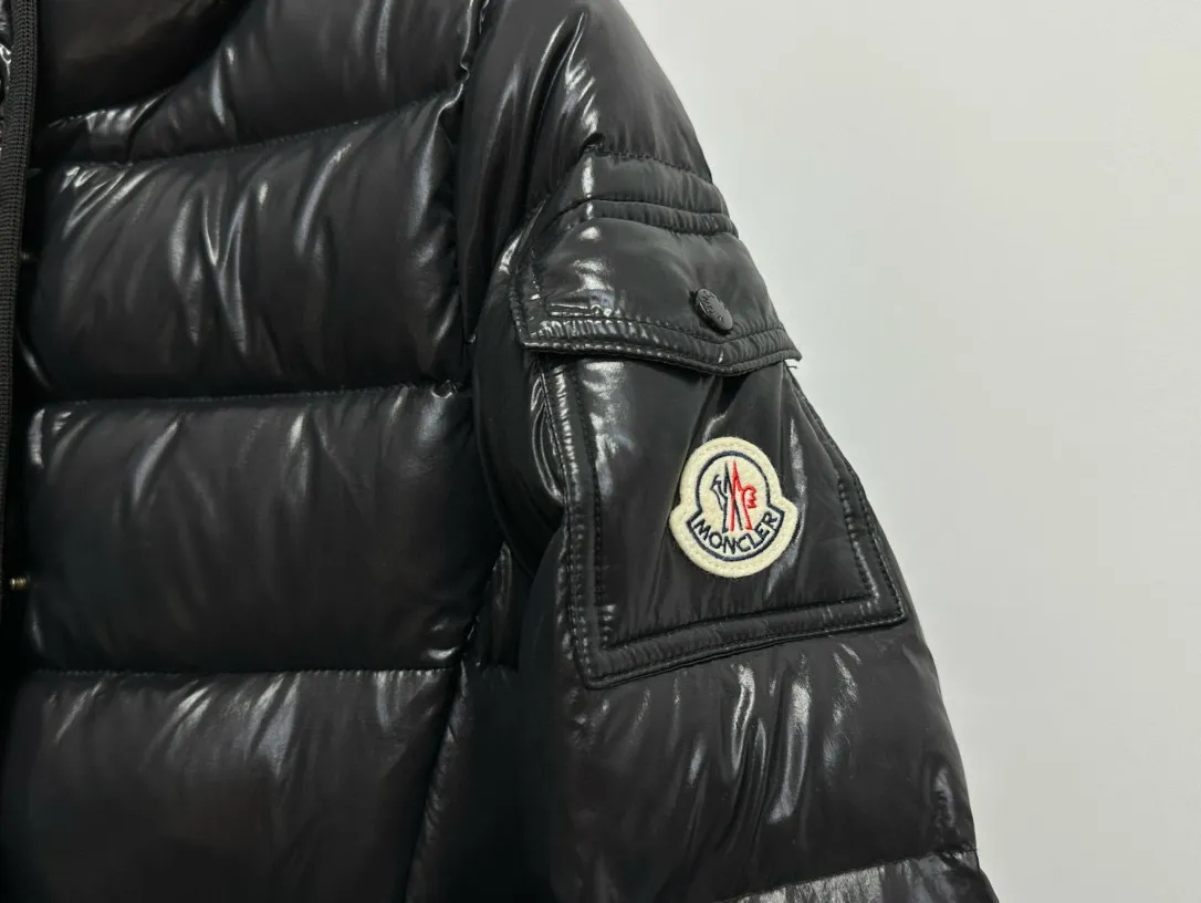 P860 [Moncler] Hooded, waisted women's short down jacket. The barante down jacket is made of glossy nylon fabric and is inspired by the 1970s. It adopts a waist design and presents an A-line silhouette, highlighting a feminine style. An adjustable hood and signature logo patch add finishing touches. Details · Made of lon laqué fabric · lon laqué lining · Filled with down · Adjustable hood · Zipper and snap closure · Suit pocket · Adjustable cuffs Size: 0/1/2/3
