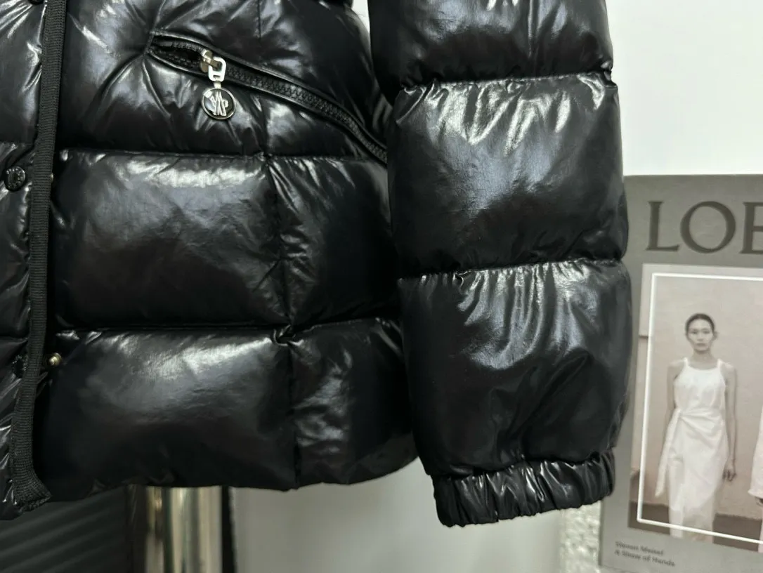 P860 [Moncler] Hooded, waisted women's short down jacket. The barante down jacket is made of glossy nylon fabric and is inspired by the 1970s. It adopts a waist design and presents an A-line silhouette, highlighting a feminine style. An adjustable hood and signature logo patch add finishing touches. Details · Made of lon laqué fabric · lon laqué lining · Filled with down · Adjustable hood · Zipper and snap closure · Suit pocket · Adjustable cuffs Size: 0/1/2/3