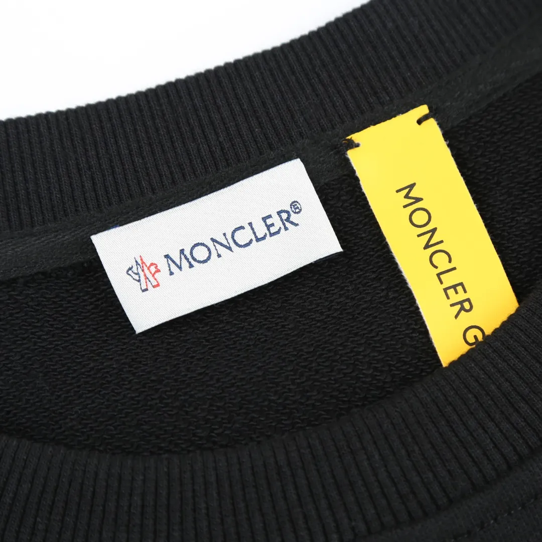 P370 MONCLER printed round neck sweatshirt Fabric selection: Single-sided fish scale fabric woven with cotton as the base. The front is a smooth knitted surface, and the skin-touching surface is formed into three-dimensional terry through the floating thread knitting technology of the knitting machine, which increases the fluffiness and has a delicate touch. The terry structure absorbs a large amount of water and evaporates quickly, so it is not easy to loosen and deform after repeated washing.  Process 1: Use glue printing to present 4 high-saturation patterns on the fabric. The pressure of the scraper is even, and the scraping printing is done in 3 times to ensure that the glue is fully penetrated and covered. After curing at high temperature, the pigment is firmly bonded to the cotton fiber. The ink-absorbing and penetrating properties of the cotton fiber make the pattern less likely to fall off due to friction.  Process 2: The 2*2 rib formed by alternating longitudinal rows of front coils and longitudinal rows of back coils is still very elastic and has a wide pattern that fits the wrist and waist without a sense of restraint. The gaps between the coils allow air to circulate without losing warmth.  Process 2: By actively interfering with the shrinkage potential of cotton fibers, the fabric is able to transition from changeable to stable, improving dimensional stability while being less prone to deformation and wrinkles.  Accessories: One to one customized 3-standard SIZE: S M L XL