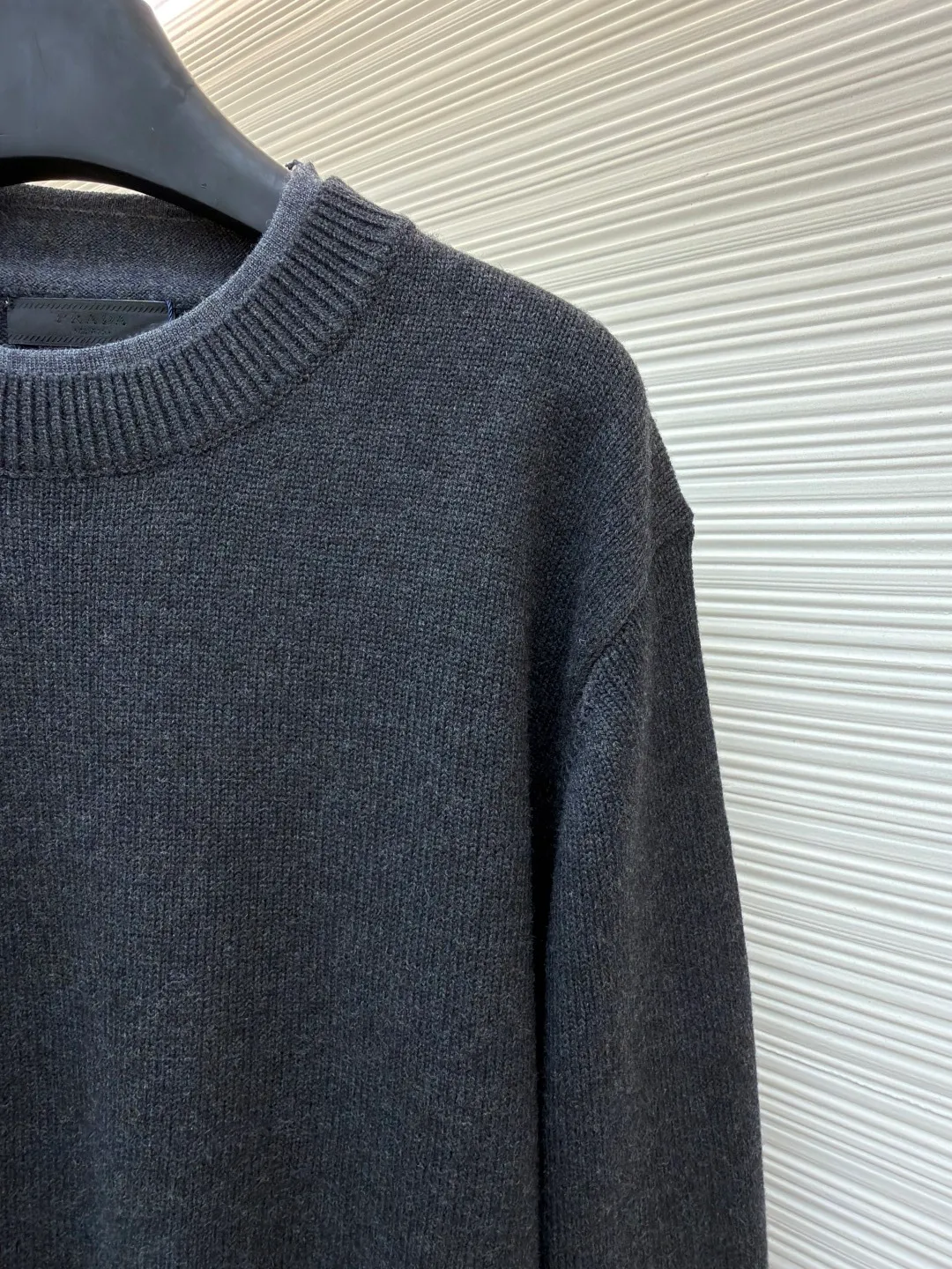Prada round neck rib knitted cuffs and hem logo sweater ●Original version: Purchased and developed by 13114 ●Item number: 1682312-A90 ●Fabric: wool fabric ●Technology: knitted ●Color: gray ●Version: fitted version ●Weight: about 765 grams ●Size: S-M-L-XL ●Description: This Prada knitted round-neck top is woven with high-count blended wool yarn imported from Italy. It is treated with a double-ply yarn process to increase the yarn's toughness by 30%, while giving the fabric a delicate matte texture and a soft and skin-friendly touch. The main body of the garment uses a 12-needle four-flat knitting method and is designed with vertical rib texture, which not only ensures a stiff silhouette and is not easily deformed, but also allows for freedom of stretching while wearing. The neckline, cuffs and hem adopt reinforced ribbing technology, and the elastic closing is formed by precise jacquard using a computerized flat knitting machine, effectively preventing loose and curling edges. The brand metal nameplate is embedded in the side seam, which is hand-polished and then seamlessly sewn together. The splicing parts of the body are all made of concealed seam technology, making the overall lines simple and smooth. Every detail demonstrates the brand's exquisite clothing craftsmanship and strict quality control. The overall wiring is straight and delicate, the fabric is comfortable and soft, and the color is consistent without color difference. It can be matched with the same style to create a fashionable look and control various occasions. Customized accessories, complete with three standards, same style for men and women!