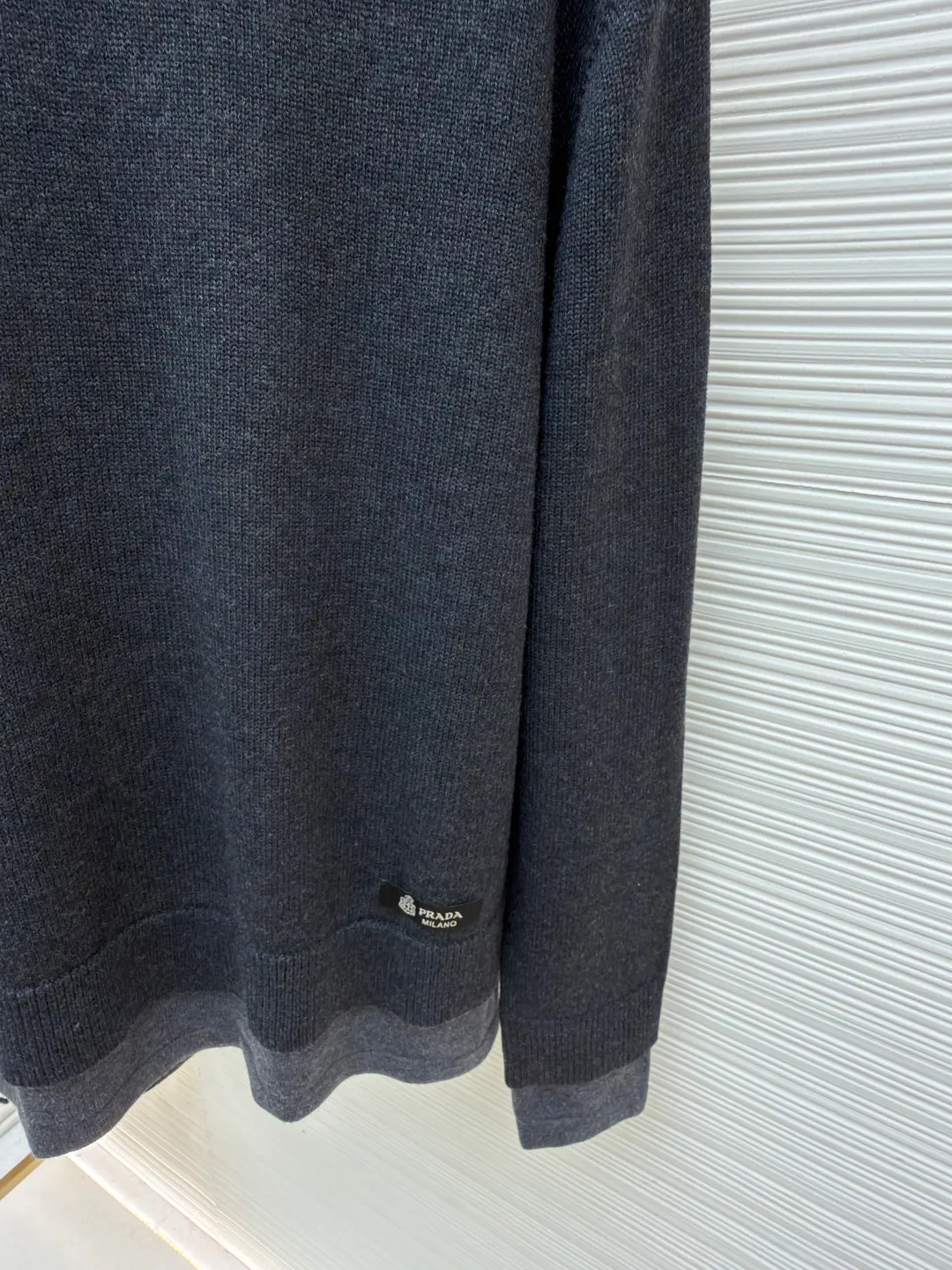 Prada round neck rib knitted cuffs and hem logo sweater ●Original version: Purchased and developed by 13114 ●Item number: 1682312-A90 ●Fabric: wool fabric ●Technology: knitted ●Color: gray ●Version: fitted version ●Weight: about 765 grams ●Size: S-M-L-XL ●Description: This Prada knitted round-neck top is woven with high-count blended wool yarn imported from Italy. It is treated with a double-ply yarn process to increase the yarn's toughness by 30%, while giving the fabric a delicate matte texture and a soft and skin-friendly touch. The main body of the garment uses a 12-needle four-flat knitting method and is designed with vertical rib texture, which not only ensures a stiff silhouette and is not easily deformed, but also allows for freedom of stretching while wearing. The neckline, cuffs and hem adopt reinforced ribbing technology, and the elastic closing is formed by precise jacquard using a computerized flat knitting machine, effectively preventing loose and curling edges. The brand metal nameplate is embedded in the side seam, which is hand-polished and then seamlessly sewn together. The splicing parts of the body are all made of concealed seam technology, making the overall lines simple and smooth. Every detail demonstrates the brand's exquisite clothing craftsmanship and strict quality control. The overall wiring is straight and delicate, the fabric is comfortable and soft, and the color is consistent without color difference. It can be matched with the same style to create a fashionable look and control various occasions. Customized accessories, complete with three standards, same style for men and women!