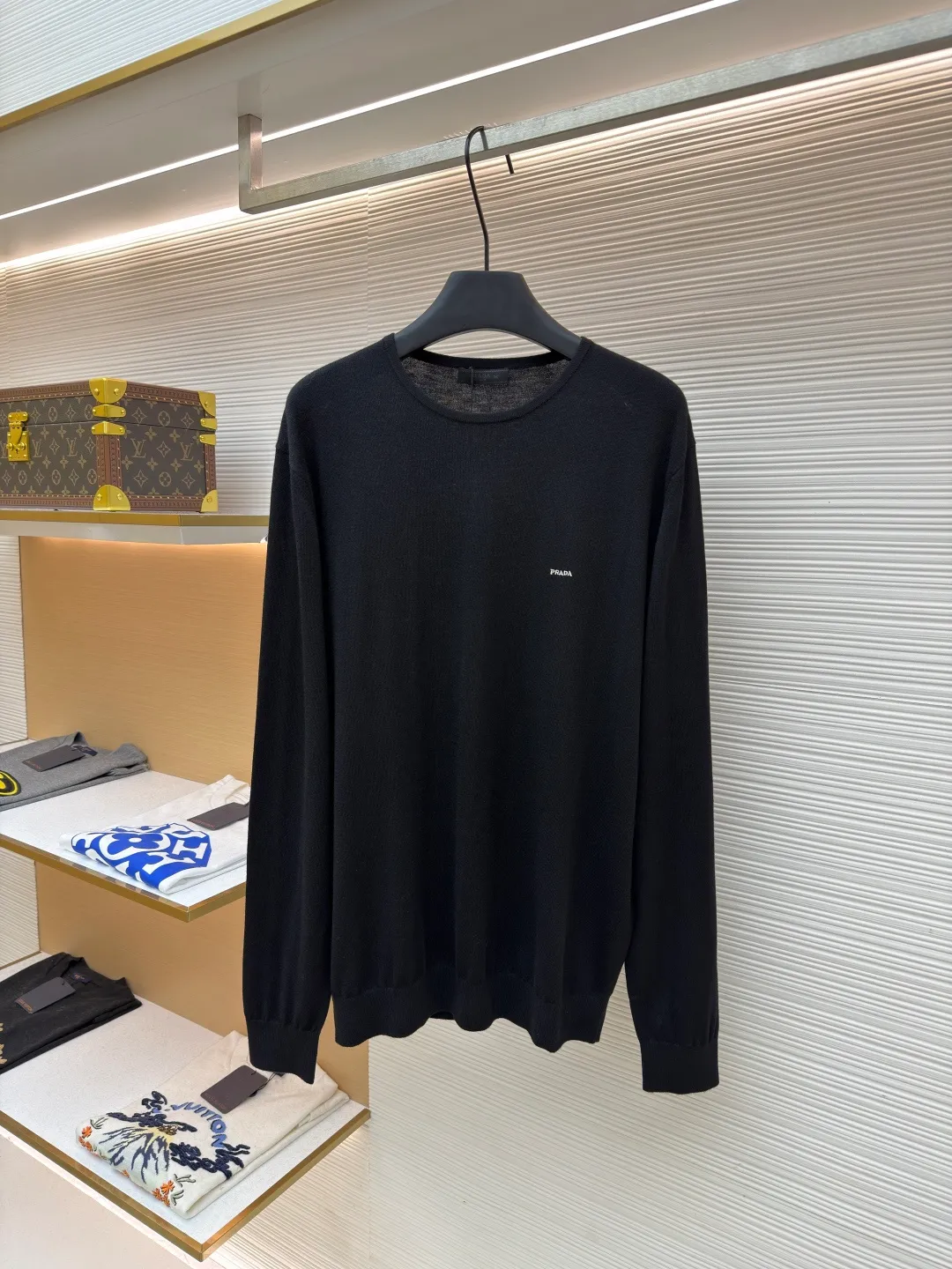 Prada Worsted Wool Long Sleeve ●Item No.: 1682330-A65 ●Material: Wool fabric ●Technology: Knitting ●Color: Black ●Version: Fitted version ●Weight: about 240 grams ●Size: S-M-L-XL ●Description: Made of fine worsted wool fiber, the sweater feels soft to the touch and is light and comfortable to wear. Wool fiber has good thermal insulation properties and is suitable for wearing in colder weather. The fiber length is moderate and free of impurities to ensure the quality and comfort of the garment. Knitted using a jersey technique, it forms the main body of the sweater. During the knitting process, the stitches must be kept even to avoid problems such as missing stitches and broken threads. After knitting is completed, the sweater needs to be ironed to make it smooth and crisp and improve the overall texture. Rib knitting technology is used for splicing to increase elasticity and fit, making the cuffs and hem tighter and more stylish. The raglan part needs to be carefully spliced ​​with the main part to ensure smooth and natural shoulder lines. The overall wiring is straight and delicate, the fabric is comfortable and soft, and the color is consistent without color difference. It can be matched with the same style to create a fashionable look and control various occasions. Customized accessories, complete with three standards, same style for men and women!