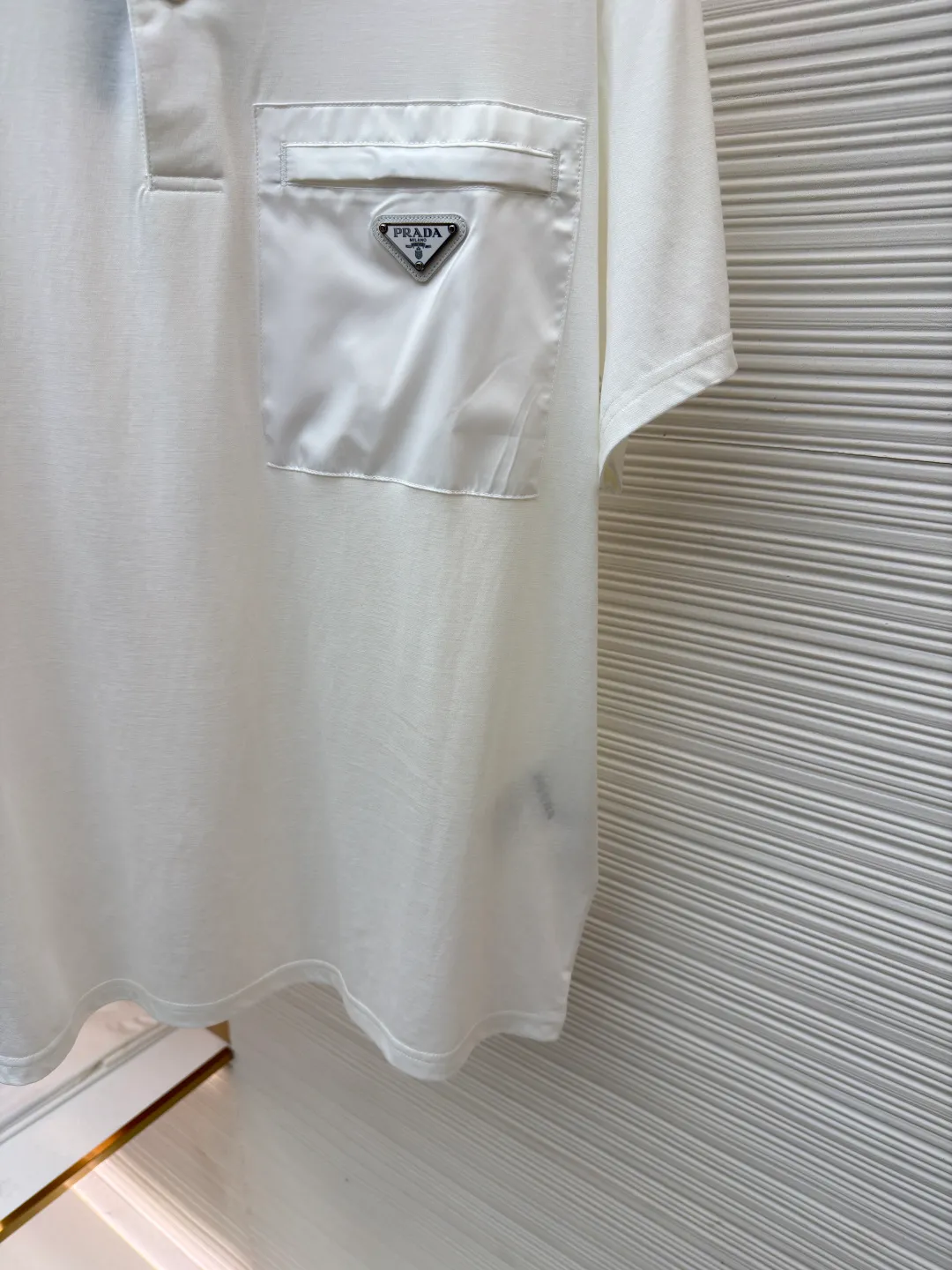 Prada Triangle Pocket Polo Shirt ●Original version: Purchased and developed at 9050 ●Item number: 1682394-A25 ●Fabric: mercerized grosgrain fabric ●Technology: needle and shuttle splicing ●Color: white ●Version: fitted version ●Weight: about 215 grams ●Size: S-M-L-XL ●Description: Customized mercerized grosgrain fabric, smooth and delicate, comfortable and close to the skin, classic black tone exudes an innate sense of luxury and is devouring with warmth The iconic triangular logo embellishes the chest, highlighting the elegance and nobility of the brand. The exquisite zipper pocket design is cleverly integrated, making the Polo shirt instantly rejuvenated. The perfect collision of simplicity and style. A versatile artifact in the wardrobe, the "Prada triangle mark" is positioned using an imported special machine infrared to position it more accurately and firmly. Needle and shuttle stitching technology can make full use of the respective advantages of knitted fabrics and woven fabrics. By choosing the appropriate sewing process and stitches, it can ensure that the splicing parts are strong and beautiful. The template machine opens the bag. The preset template guides the position, shape and size of the bag opening. The accuracy ensures the quality of the bag opening effect. The overall wiring is straight and delicate, the fabric is comfortable and soft, and the color is consistent without color difference. It can be matched with the same style to create a fashionable look and control various occasions. Customized accessories, complete with three standards, same style for men and women!