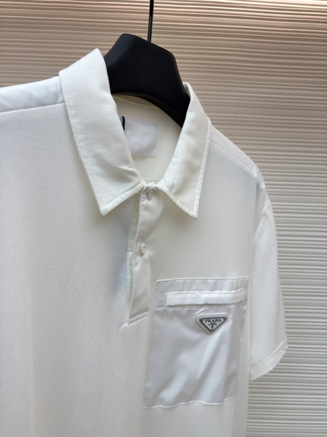 Prada Triangle Pocket Polo Shirt ●Original version: Purchased and developed at 9050 ●Item number: 1682394-A25 ●Fabric: mercerized grosgrain fabric ●Technology: needle and shuttle splicing ●Color: white ●Version: fitted version ●Weight: about 215 grams ●Size: S-M-L-XL ●Description: Customized mercerized grosgrain fabric, smooth and delicate, comfortable and close to the skin, classic black tone exudes an innate sense of luxury and is devouring with warmth The iconic triangular logo embellishes the chest, highlighting the elegance and nobility of the brand. The exquisite zipper pocket design is cleverly integrated, making the Polo shirt instantly rejuvenated. The perfect collision of simplicity and style. A versatile artifact in the wardrobe, the "Prada triangle mark" is positioned using an imported special machine infrared to position it more accurately and firmly. Needle and shuttle stitching technology can make full use of the respective advantages of knitted fabrics and woven fabrics. By choosing the appropriate sewing process and stitches, it can ensure that the splicing parts are strong and beautiful. The template machine opens the bag. The preset template guides the position, shape and size of the bag opening. The accuracy ensures the quality of the bag opening effect. The overall wiring is straight and delicate, the fabric is comfortable and soft, and the color is consistent without color difference. It can be matched with the same style to create a fashionable look and control various occasions. Customized accessories, complete with three standards, same style for men and women!