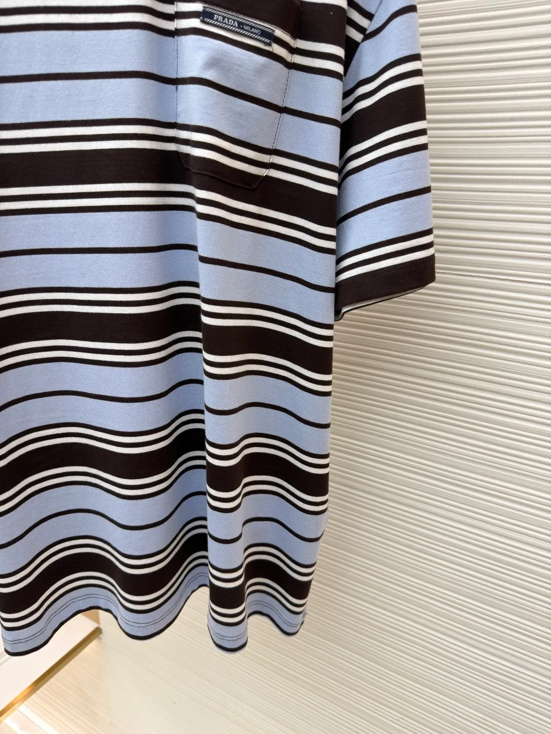 Prada striped pocket short sleeves ●Original version: Purchased and developed at 9650 ●Item number: 1682384-A00 ●Material: exclusive striped fabric ●Technology: fabric washed and made ●Color: blue, white and brown ●Version: fitted version ●Weight: about 175 grams ●Size: 36-38-40-42 ●Description: Customized precision 60 double-strand exclusive striped fabric, delicate and soft, comfortable and close to the skin, a touch of sky blue quietly blooms Dynamic and energetic, fresh and elegant, the breast pocket is decorated with the brand logo as the finishing touch, highlighting the brand identity symbol. The stripe element is like a smart musical note. When the stripes become a flowing sea, every inch of sky blue is a gentle deconstruction of order. The beauty of layers is all in the strips, ergonomic three-dimensional tailoring. Return to traditional craftsmanship through segmentation, folding, shrinking and stretching techniques. The so-called slow work produces fine work, which is the respect for materials and the pursuit of feel. Complex workmanship, tedious and slow aging. Manual infrared line drawing pockets use infrared technology as an aid to achieve precise positioning and marking of pocket positions, while retaining the precision and flexibility of hand sewing. The fabrics have been washed to give them a better feel and texture. They are not easy to deform, shrink or fade, and maintain their long-lasting beauty. The overall wiring is straight and delicate, the fabric is comfortable and soft, and the color is consistent without color difference. It can be matched with the same style to create a fashionable look and control various occasions. Customized accessories, complete with three standards, same style for men and women!