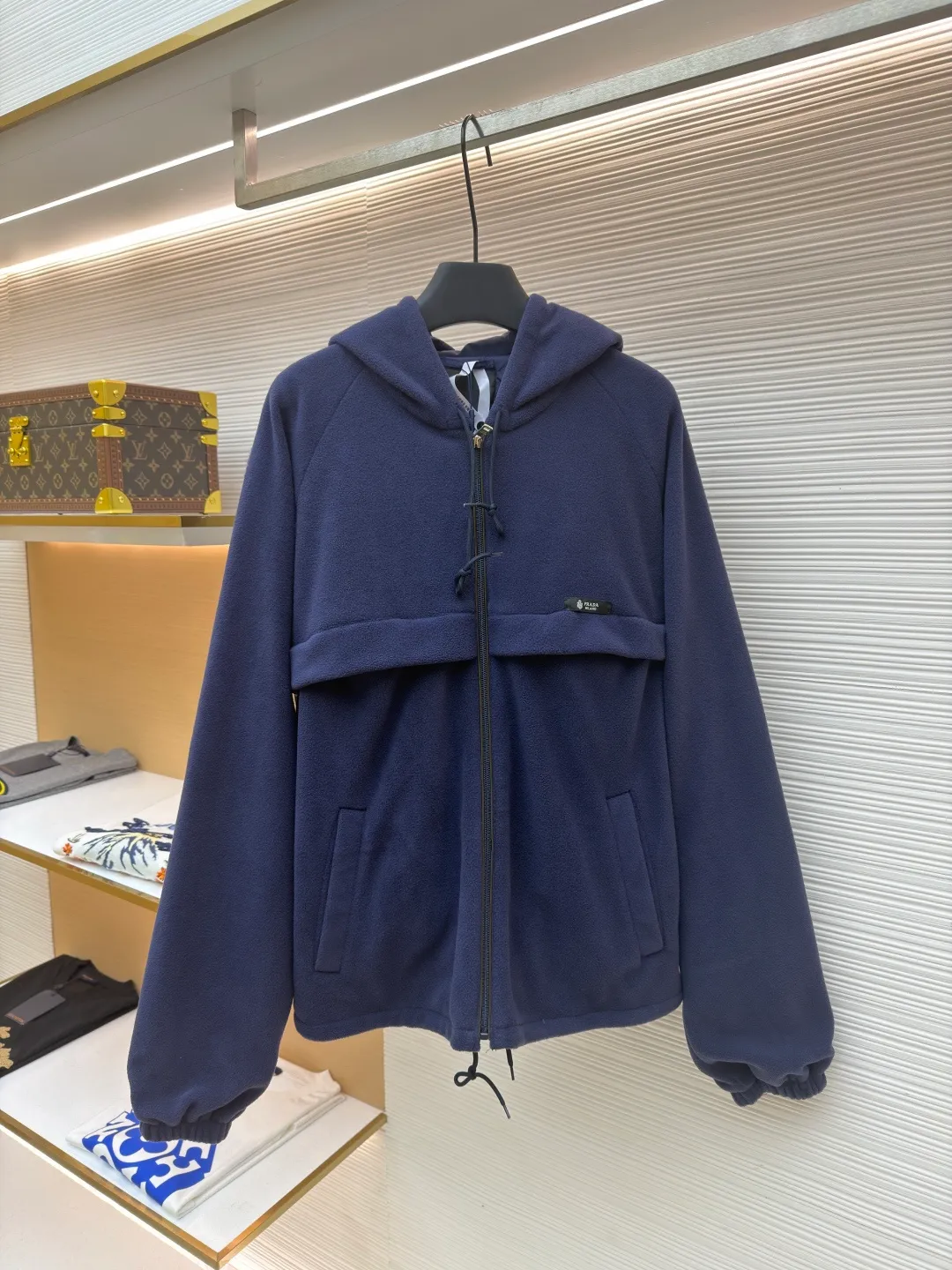 Prada hooded drawstring fabric short jacket ●Original version: Purchased and developed for 22300 ●Item number: 1682436-B25 ●Fabric: polar fleece fabric ●Technology: hand-sewn label production ●Color: navy blue ●Version: fitted version ●Weight: about 720 grams ●Size: 46-48-50-52 ●Description: This PRADA hooded drawstring fabric short jacket is made of high-quality fabric as the core material. It is first treated with an enzyme washing process to make the fabric soft and skin-friendly. It also enhances the wrinkle resistance and color fastness of the fabric, making the navy blue tone more textured and not easy to fade. The body is designed with a short cut and is equipped with a hooded drawstring structure. The drawstring is treated with reinforced stitching to ensure smooth adjustment and durability. The shoulders are made of raglan sleeves, which improves the freedom of movement of the wearer. Flat seams are used at the splicing between the pockets and the body, and the stitching is neat and precise. The brand logo is fixed through hand-sewing technology, and the stitching is even and firm, retaining the brand texture. The entire garment is stitched with high-tenacity stitches of the same color. The measurement error of 1~3cm is within the normal range. The overall craftsmanship takes into account both functionality and luxury details. Hand washing is recommended to maintain the integrity of the fabric and craftsmanship. The overall wiring is straight and delicate, the fabric is comfortable and soft, and the color is consistent without color difference. It can be matched with the same style to create a fashionable look and control various occasions. Customized accessories, complete with three standards, same style for men and women!
