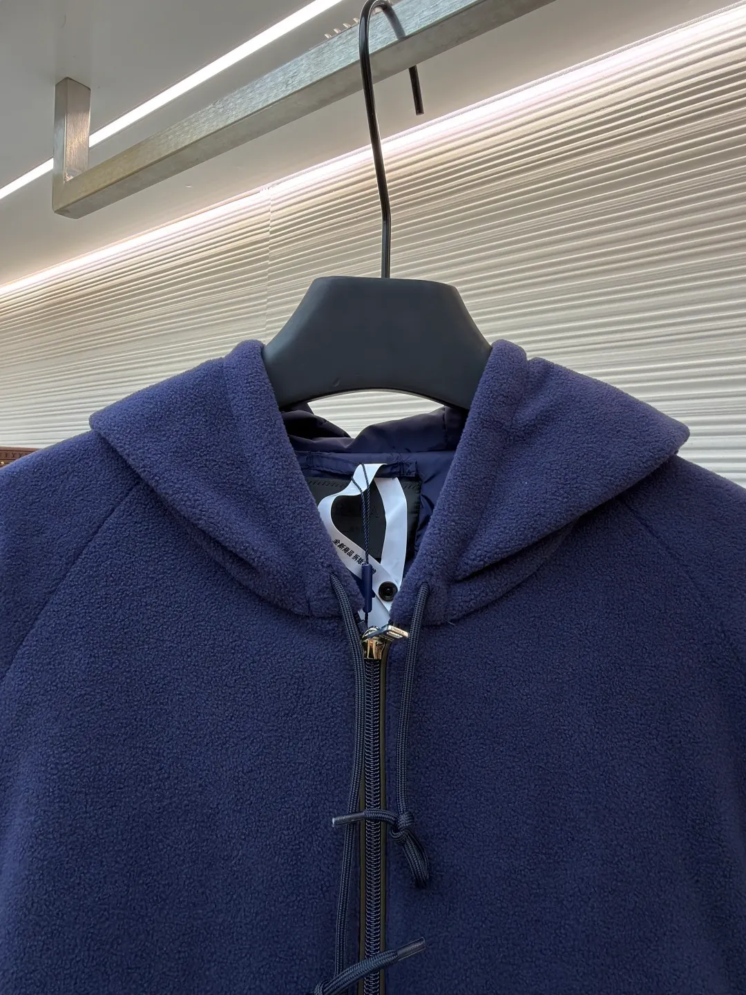 Prada hooded drawstring fabric short jacket ●Original version: Purchased and developed for 22300 ●Item number: 1682436-B25 ●Fabric: polar fleece fabric ●Technology: hand-sewn label production ●Color: navy blue ●Version: fitted version ●Weight: about 720 grams ●Size: 46-48-50-52 ●Description: This PRADA hooded drawstring fabric short jacket is made of high-quality fabric as the core material. It is first treated with an enzyme washing process to make the fabric soft and skin-friendly. It also enhances the wrinkle resistance and color fastness of the fabric, making the navy blue tone more textured and not easy to fade. The body is designed with a short cut and is equipped with a hooded drawstring structure. The drawstring is treated with reinforced stitching to ensure smooth adjustment and durability. The shoulders are made of raglan sleeves, which improves the freedom of movement of the wearer. Flat seams are used at the splicing between the pockets and the body, and the stitching is neat and precise. The brand logo is fixed through hand-sewing technology, and the stitching is even and firm, retaining the brand texture. The entire garment is stitched with high-tenacity stitches of the same color. The measurement error of 1~3cm is within the normal range. The overall craftsmanship takes into account both functionality and luxury details. Hand washing is recommended to maintain the integrity of the fabric and craftsmanship. The overall wiring is straight and delicate, the fabric is comfortable and soft, and the color is consistent without color difference. It can be matched with the same style to create a fashionable look and control various occasions. Customized accessories, complete with three standards, same style for men and women!