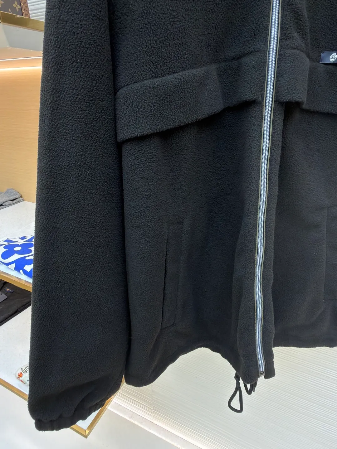 Prada Polar Fleece Jacket ●Original version: Purchased and developed by 13138 ●Item No.: 1682329-B50 ●Fabric: Polar fleece fabric ●Technology: Positioned cutting machine production ●Color: black ●Version: Fitted version ●Weight: about 635 grams ●Size: S-M-L-XL ●Description: The woven fabric is brushed, that is, the fiber surface is fluffed through mechanical brushing to form fluff. Then the shaking process is carried out. The fabric is shaken under high temperature and humid conditions, so that the fibers form small spherical particles, which increases the fluffiness and warmth of the fabric. Polar fleece fabric undergoes a dyeing process to ensure uniform and long-lasting color. After dyeing, the fabric undergoes finishing processes such as shaping and calendering to improve the feel and appearance. Splice the cut parts (such as front and back panels, sleeves, hats, etc.) according to the design requirements. When splicing, you need to pay attention to aligning the seams to ensure that the splicing is smooth and wrinkle-free. For parts that are prone to wear, such as collars, cuffs, and hems, hemming is used to increase elasticity and durability. At the same time, details such as zippers and pockets also need to be carefully processed to ensure functionality and aesthetics. Choose high-quality metal zippers to ensure that the zippers are smooth and durable. The color of the zipper needs to be coordinated with the color of the main body of the jacket to enhance the overall aesthetics. The overall wiring is straight. Delicate, the fabric is comfortable and soft, the color is consistent and there is no color difference. It can be matched with the same style to create a fashionable look and control various occasions. Customized accessories, complete with three standards, same style for men and women!