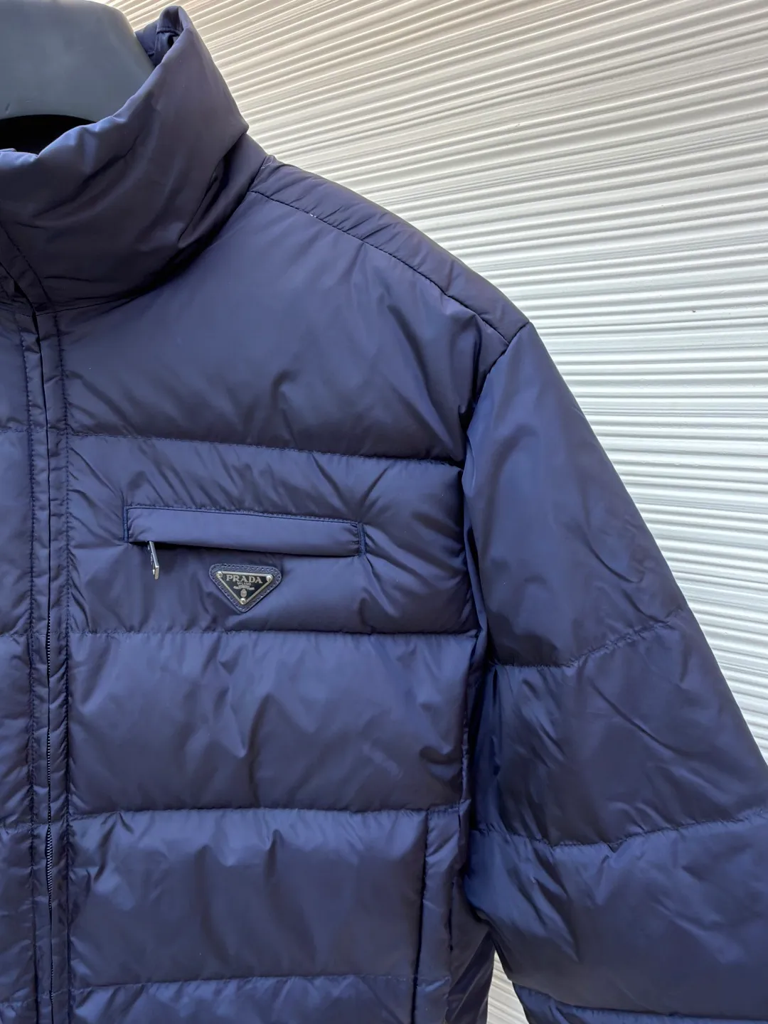 Prada triangle pocket down jacket ●Original version: Purchased and developed in 19800 ●Item number: 1681903-D20 ●Fabric: white duck down fabric ●Technology: mechanical down filling ●Color: navy blue ●Version: fitted version ●Weight: about 675 grams ●Size: 46-48-50-52 ●Description: Customized ultra-dense round hole woven fabric (with anti-repellent treatment) showing a matte micro-texture Use the new national standard 90 white duck down (welcome to test), full of down, full of warmth, you are in a warm cloud, surrounded by soft warmth, the classic black tone exudes an innate sense of luxury, the iconic enameled metal triangle logo is embellished on the chest, low-key and powerful, the stand-up collar is crisp and stylish, accurately fits the neck curve, and uses architectural lines to reconstruct the warmth and neatness of the bloated down jacket. Enjoy warmth and comfort. Become the most considerate companion for mechanical down filling in winter. Prioritize the filling area by making the liner pattern to determine the gram weight of down per square meter according to the original three-dimensional effect, thereby calculating the filling amount of each piece. The computer down filling machine uses a digital weighing unit to achieve stable measurement, and uses imported special machine infrared to locate the "Prada triangle mark" for more accurate positioning. The firm and strong template machine opens the zipper bag. The lines are smooth and tidy. The wiring is even and the template machine lines the lines. The line process of the computer template machine shows extremely high neatness and smoothness. The craftsman accurately controls the size during the operation to ensure that each line meets the design requirements. The lines of the entire template are smooth and uniform, clean and beautiful. The overall wiring is straight and delicate, the fabric is comfortable and soft, and the color is consistent without color difference. It can be matched with the same style to create a fashionable look and control various occasions. Customized accessories, complete with three standards, same style for men and women!