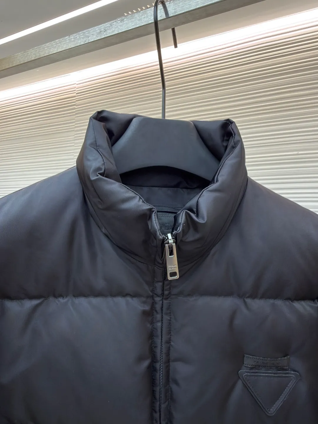 Prada nylon triangle down jacket ●Original version: Purchased and developed by 13557 ●Item number: 1681282-C95 ●Fabric: white duck down fabric ●Technology: mechanical down filling ●Color: black ●Version: fitted version ●Weight: about 1025 grams ●Size: S-M-L-XL ●Description: Made of high-count and high-density nylon woven fabric, it is a lightweight, strong and fine-textured advanced fabric. Its physical complexity lies in the fact that while achieving extreme lightweight, it provides excellent tear resistance and abrasion resistance through a dense fabric structure, solving the industry problem of light weight and durability that are often contradictory. Waterproof coating: This is not a simple film, but a microscopic functional polymer layer coated on the surface of the fabric after it is woven. Its complexity is reflected in its chemical properties: it can effectively reduce the surface tension of the fabric, making it impossible for water droplets to penetrate its fiber gaps, thereby forming a lotus leaf effect and achieving efficient waterproofing. At the same time, this coating usually has a certain degree of breathability, allowing moisture emitted by the body to escape and maintaining a comfortable internal microclimate. This is a precise balancing technology. The laser-burned triangle mark on the chest is the pinnacle of the complexity of the entire garment's craftsmanship. Laser burning is a non-contact precision processing technology. Using a laser beam of specific wavelength and energy, the fibers on the surface of the fabric are vaporized according to a preset digital path. The laser can accurately "carve" every detail of the logo without damaging the underlying fabric structure, with clear and sharp edges and a unique, slightly burning matte texture. This is completely different from traditional embroidery or offset printing. It is integrated with the fabric itself and cannot be peeled off. It also requires extremely high stability in process control - if the energy is slightly weaker, the pattern will be unclear, and if the energy is slightly stronger, it may penetrate the fabric. The core is filled with 90% pure white duck down. "90% pure white duck down" is an indicator that has been strictly sorted. The thermal insulation principle of down is that its three-dimensional velvet can hold a large amount of still air and form an efficient thermal insulation layer. To sum up, every part of this down jacket goes beyond basic functions and embodies full-link innovation and quality control from raw material selection, textile engineering, chemical processing to digital finishing. The overall wiring is straight and delicate, the fabric is comfortable and soft, and the color is consistent without color difference. It can be matched with the same style to create a fashionable look and control various occasions. Customized accessories, complete with three standards, same style for men and women!