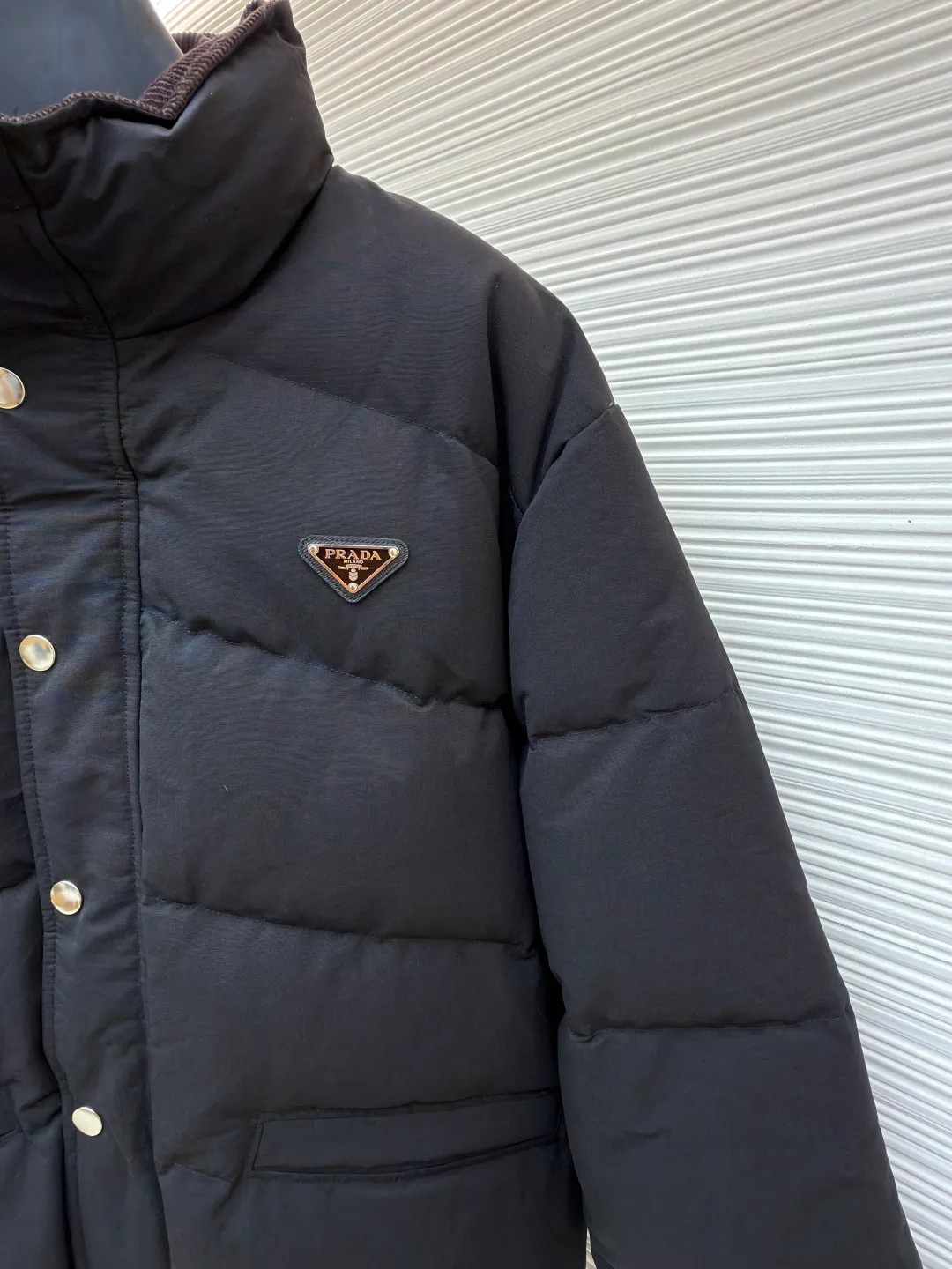 Prada down jacket with triangle stand collar ●Original version: purchased and developed by 15436 ●Item number: 1681713-D15 ●Fabric: white duck down fabric ●Technology: mechanical down filling ●Color: black ●Version: fitted version ●Weight: about 1105 grams ●Size: S-M-L-XL ●Description: Selected high-count poplin fabric, showing a unique matte texture, high-count and high-density weaving with fine warp yarns and thick weft yarns. The unique cross texture on the surface is stiffer than ordinary cotton and more skin-friendly than nylon. Filled with 90% selected white duck down and weighing 230g, it ensures fluffiness, quick rebound, lightness and warmth. The quilting stitches are sewn in a diagonal direction at an angle of about 65 degrees, and the diagonal lines are arranged in parallel. The fabric and filling are planned into different functional areas, and the quilting stitches in each partition are relatively independent. This allows the finished product to produce a larger deformation space along the diagonal direction when stretched and pressed, making it less likely to tighten and break. The diamond grid has a strong sense of direction and movement, and the visual effect is rich, modern and advanced. The overall wiring is straight and delicate, the fabric is comfortable and soft, and the color is consistent without color difference. It can be matched with the same style to create a fashionable look and control various occasions. Customized accessories, complete with three standards, same style for men and women!