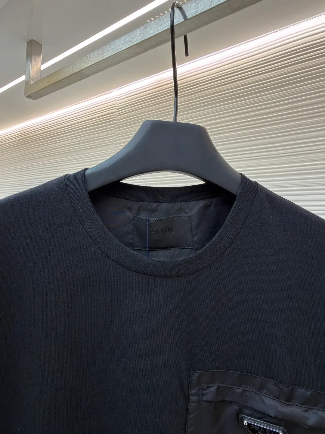 Prada Triangle Logo Pocket Short Sleeves ●Original version: Purchased and developed for 7000 ●Item number: 1682396-A05 ●Fabric: High-elastic jersey fabric ●Technology: Needle and shuttle stitching ●Color: black ●Version: Fitted version ●Weight: about 235 grams ●Size: S-M-L-XL ●Description: Customized high-elastic jersey material, delicate and soft, comfortable and close to the skin, a touch of simple white, pure and elegant. The iconic Prada triangle logo is embellished on the chest. It is integrated with Re-Nylon nylon fabric to decorate the square silhouette. Cross-disciplinary aesthetic grafting. The exquisite small pocket design highlights quality and style. It reveals a flexible and relaxed beauty. It is a picture of strolling in the city and deconstructs the attitude of the modern gentleman. The infrared positioning of the "Prada triangle mark" by an imported special machine is more precise and firm. Needle and shuttle stitching technology can make full use of the respective advantages of knitted fabrics and woven fabrics. By choosing the appropriate sewing process and stitches, it can ensure that the splicing parts are strong and beautiful. Template machine bag opening The preset template guides the position, shape and size of the bag opening. The accuracy ensures the quality of the bag opening effect. The overall wiring is straight and delicate, the fabric is comfortable and soft, and the color is consistent without color difference. It can be matched with the same style to create a fashionable look and control various occasions. Customized accessories, complete with three standards, same style for men and women!