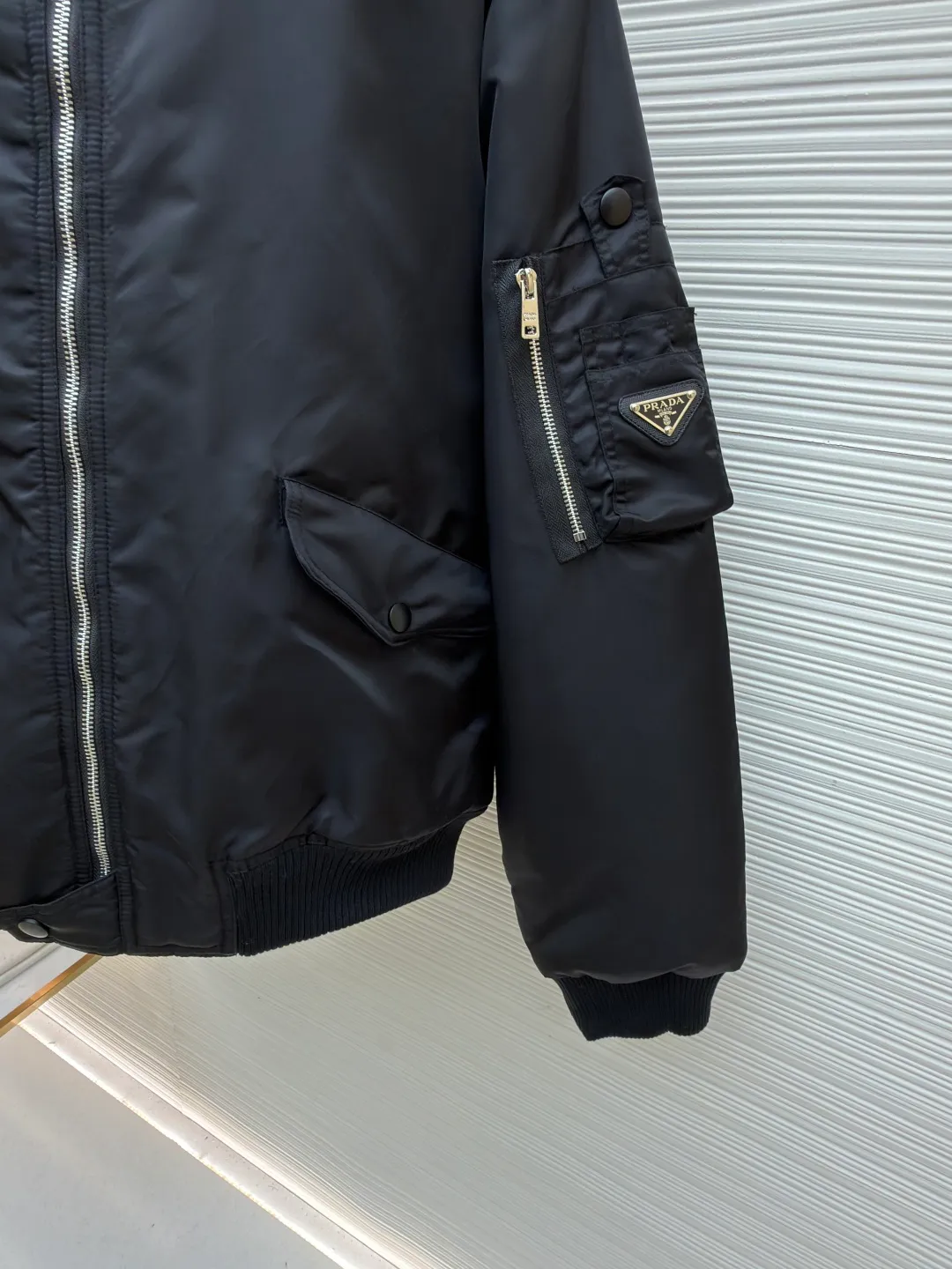 Prada sleeve bomber bomber jacket cotton ●Original version: Purchased and developed at 18475 ●Item number: 1682145-C45 ●Fabric: Regenerated nylon fabric ●Technology: Positioning cutting machine production ●Color: black ●Version: fitted version ●Weight: about 1115 grams ●Size: S-M-L-XL ●Description: The fabric is made of customized regenerated nylon. The main features of this nylon fabric are environmental protection, circular economy, performance and texture, wear resistance The look and feel remains premium. The filling is made of high-quality pearl cotton. This cotton is not a traditional wadding, but a hollow three-dimensional crimped fiber formed through a special process. Diamond-shaped mesh stitching inside and outside prevents the down from shifting and accumulating during use, ensuring even distribution of thermal insulation properties. Customized hardware accessories include triangle labels, engraved zippers, and buttons. The overall wiring is straight and delicate, the fabric is comfortable and soft, and the color is consistent without color difference. It can be matched with the same style to create a fashionable look and control various occasions. Customized accessories, complete with three standards, same style for men and women!