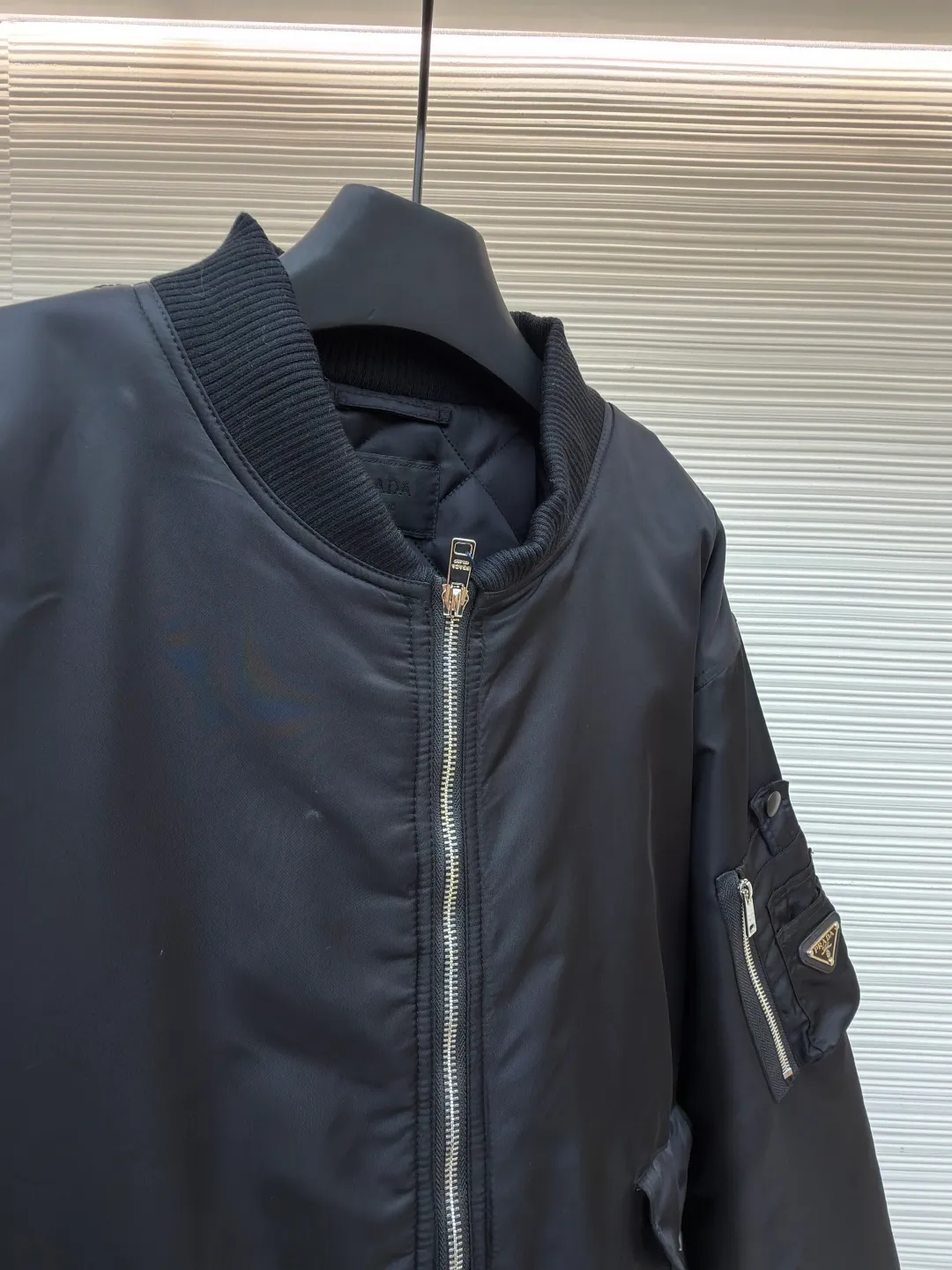 Prada sleeve bomber bomber jacket cotton ●Original version: Purchased and developed at 18475 ●Item number: 1682145-C45 ●Fabric: Regenerated nylon fabric ●Technology: Positioning cutting machine production ●Color: black ●Version: fitted version ●Weight: about 1115 grams ●Size: S-M-L-XL ●Description: The fabric is made of customized regenerated nylon. The main features of this nylon fabric are environmental protection, circular economy, performance and texture, wear resistance The look and feel remains premium. The filling is made of high-quality pearl cotton. This cotton is not a traditional wadding, but a hollow three-dimensional crimped fiber formed through a special process. Diamond-shaped mesh stitching inside and outside prevents the down from shifting and accumulating during use, ensuring even distribution of thermal insulation properties. Customized hardware accessories include triangle labels, engraved zippers, and buttons. The overall wiring is straight and delicate, the fabric is comfortable and soft, and the color is consistent without color difference. It can be matched with the same style to create a fashionable look and control various occasions. Customized accessories, complete with three standards, same style for men and women!