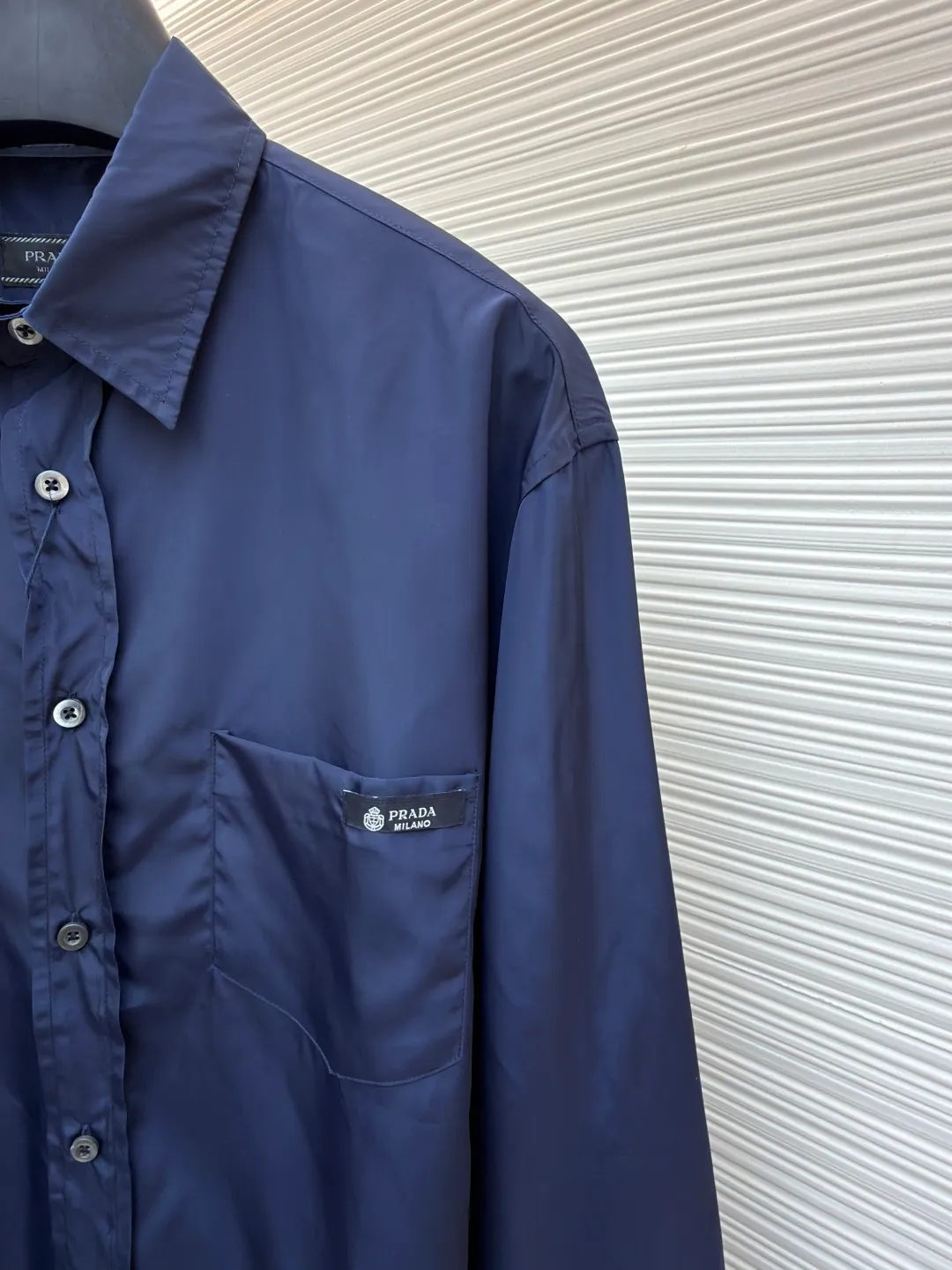 Prada triangle emblem label shirt ●Original version: Purchased and developed by 8100 ●Item number: 1682219-A75 ●Material: Regenerated nylon fabric ●Technology: Human body draping and production ●Color: blue ●Version: Fitted version ●Weight: about 180 grams ●Size: 39-40-41-42 ●Description: Custom-dyed regenerated nylon material feels like futuristic technology, light and tough, comfortable and skin-friendly Reconstructing the aesthetics of masculine power with deep sea blue tones. It has a mysterious and elegant aura. The Prada logo label is embellished on the chest patch pocket and complements the triangular logo on the back fabric to express the brand identity. The slightly wide shoulder line and curved hem form an architectural-level silhouette. The visual aristocratic gene, minimalism and luxury coexist, interpreting high-end fashion style. Silk double yarn interweaving processing technology uses nano-imprint technology to build honeycomb-shaped protrusions on the surface of the fabric, and then uses high temperature and high pressure to form covalent bonds between fluorine atoms and nylon fibers, forming a micro-matte film layer on the surface to prevent oil stains from reducing the waterproof performance. Three-dimensional tailoring of the human body returns to traditional craftsmanship through segmentation, folding, shrinking, and stretching techniques. The so-called slow work produces fine work, which is the respect for the material and the pursuit of feel. The workmanship is complicated and tedious, and the timeliness is slow. The side-turning buried clamping line process is used to make it smooth, neat, and tidy. The overall wiring is straight and delicate, the fabric is comfortable and soft, and the color is consistent without color difference. It can be matched with the same style to create a fashionable look and control various occasions. Customized accessories, complete with three standards, same style for men and women!