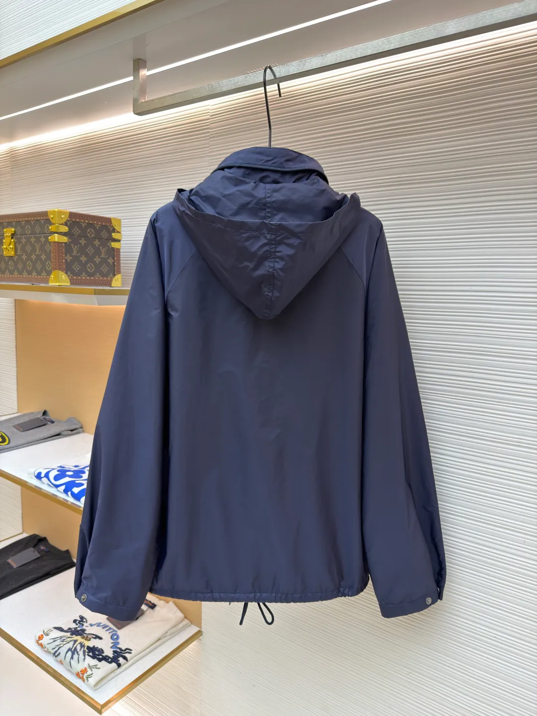 Prada Regenerated Nylon Fleece Jacket ●Original version: Purchased and developed by 12048 ●Item number: 1682331-B70 ●Fabric: Regenerated nylon fabric ●Technology: Made on positioning cutting machine ●Color: Navy blue ●Version: Fitted version ●Weight: about 585 grams ●Size: S-M-L-XL ●Description: High-density yarn is made by melt spinning through a special process. The yarn has been stretched and twisted through multiple processes to give the fabric the stiffness and wrinkle resistance that are comparable to those of native materials, while retaining a light and drapey wearing experience. The surface of the fabric is treated with an environmentally friendly coating process to form a micro-waterproof film layer, which is both windproof and breathable. The main raw material is polyester fiber blended wool raw material which is cleaned and pre-treated to remove impurities. After the yarn is woven into fabric through a loom, it is brushed, that is, the surface of the fiber is fluffed through mechanical brushing to form fluff. Then the shaking process is carried out, and the fabric is shaken under high temperature and humid conditions, so that the fibers form small spherical particles to increase the thermal insulation performance. The shoulder splicing uses twill sewing technology, the raglan sleeve design releases shoulder movement space, and the regular shoulder line ensures the stiffness of the overall silhouette, maintaining an elegant silhouette for both sports and static wear. The three-dimensional pleat design is incorporated into both sides of the body and sleeve elbows, and a long-lasting pleat texture is formed through high-temperature setting technology. This not only enhances the aerodynamic performance of the fabric, but also enriches the visual hierarchy with light and shadow changes, breaking the dull feeling of solid color fabrics. The cuffs are equipped with a hidden snap-button adjustment system, which can be freely tightened according to the circumference of the wrist to prevent cold wind from entering; the straight bottom edge is matched with a drawstring at the hem, and the inner rope buckle design can be used to adjust the tightness, taking into account warmth preservation and waistline shaping. The overall wiring is straight and delicate, the fabric is comfortable and soft, and the color is consistent without color difference. It can be matched with the same style to create a fashionable look and control various occasions. Customized accessories, complete with three standards, same style for men and women!