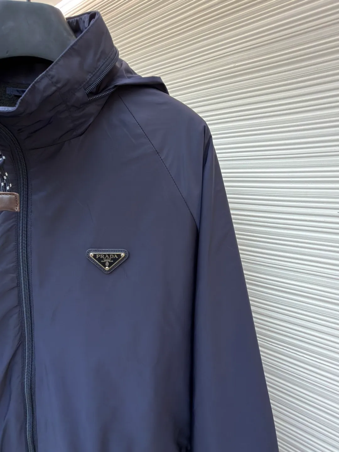 Prada Regenerated Nylon Fleece Jacket ●Original version: Purchased and developed by 12048 ●Item number: 1682331-B70 ●Fabric: Regenerated nylon fabric ●Technology: Made on positioning cutting machine ●Color: Navy blue ●Version: Fitted version ●Weight: about 585 grams ●Size: S-M-L-XL ●Description: High-density yarn is made by melt spinning through a special process. The yarn has been stretched and twisted through multiple processes to give the fabric the stiffness and wrinkle resistance that are comparable to those of native materials, while retaining a light and drapey wearing experience. The surface of the fabric is treated with an environmentally friendly coating process to form a micro-waterproof film layer, which is both windproof and breathable. The main raw material is polyester fiber blended wool raw material which is cleaned and pre-treated to remove impurities. After the yarn is woven into fabric through a loom, it is brushed, that is, the surface of the fiber is fluffed through mechanical brushing to form fluff. Then the shaking process is carried out, and the fabric is shaken under high temperature and humid conditions, so that the fibers form small spherical particles to increase the thermal insulation performance. The shoulder splicing uses twill sewing technology, the raglan sleeve design releases shoulder movement space, and the regular shoulder line ensures the stiffness of the overall silhouette, maintaining an elegant silhouette for both sports and static wear. The three-dimensional pleat design is incorporated into both sides of the body and sleeve elbows, and a long-lasting pleat texture is formed through high-temperature setting technology. This not only enhances the aerodynamic performance of the fabric, but also enriches the visual hierarchy with light and shadow changes, breaking the dull feeling of solid color fabrics. The cuffs are equipped with a hidden snap-button adjustment system, which can be freely tightened according to the circumference of the wrist to prevent cold wind from entering; the straight bottom edge is matched with a drawstring at the hem, and the inner rope buckle design can be used to adjust the tightness, taking into account warmth preservation and waistline shaping. The overall wiring is straight and delicate, the fabric is comfortable and soft, and the color is consistent without color difference. It can be matched with the same style to create a fashionable look and control various occasions. Customized accessories, complete with three standards, same style for men and women!