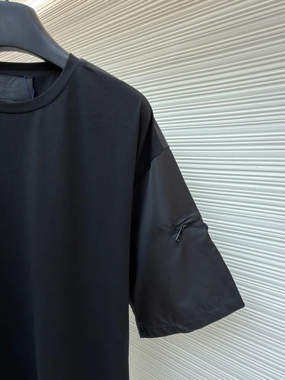 Prada triangle logo inlaid pocket short sleeves ●Original version: Purchased and developed at 9050 ●Item No.: 1682427-A15 ●Fabric: Helium-etched mercerized satin fabric ●Technology: Needle and shuttle stitching ●Color: Black ●Version: Fitted version ●Weight: about 285 grams ●Size: S-M-L-XL ●Description: Customized helium-etched mercerized satin, smooth and delicate, comfortable and close to the skin The iconic enameled triangular metal logo decorates the sleeves. Re-Nylon nylon fabric is used to embellish the square silhouette. Cross-disciplinary aesthetic grafting. Exquisite small pocket design highlights quality and style. It reveals a flexible and relaxed beauty. It is a picture of strolling in the city and deconstructs the attitude of the modern gentleman. The infrared positioning of the "Prada triangle mark" by an imported special machine is more precise and firm. Needle and shuttle stitching technology can make full use of the respective advantages of knitted fabrics and woven fabrics. By choosing the appropriate sewing process and stitches, it can ensure that the splicing parts are strong and beautiful. The template machine opens the bag. The preset template guides the position, shape and size of the bag opening. The accuracy ensures the quality of the bag opening effect. The overall wiring is straight and delicate, the fabric is comfortable and soft, and the color is consistent without color difference. It can be matched with the same style to create a fashionable look and control various occasions. Customized accessories, complete with three standards, same style for men and women!