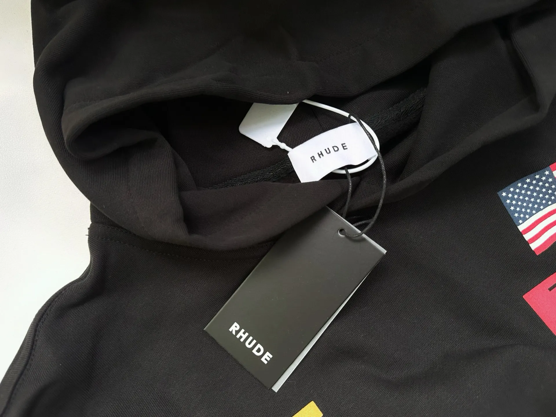 Style number: 8888 P246 RHUDE × PIRELLI Burning Aesthetics New Hooded Sweatshirt When the speed language of racing enters the fashion context, the cooperation between RHUDE and PIRELLI has become a precise and restrained cultural injection. 	 Suede printing process + using pure cotton terry brushed process fabric 450 grams, heavy upper body three-dimensional fluffy Size: (S-M-L-XL) Color: black