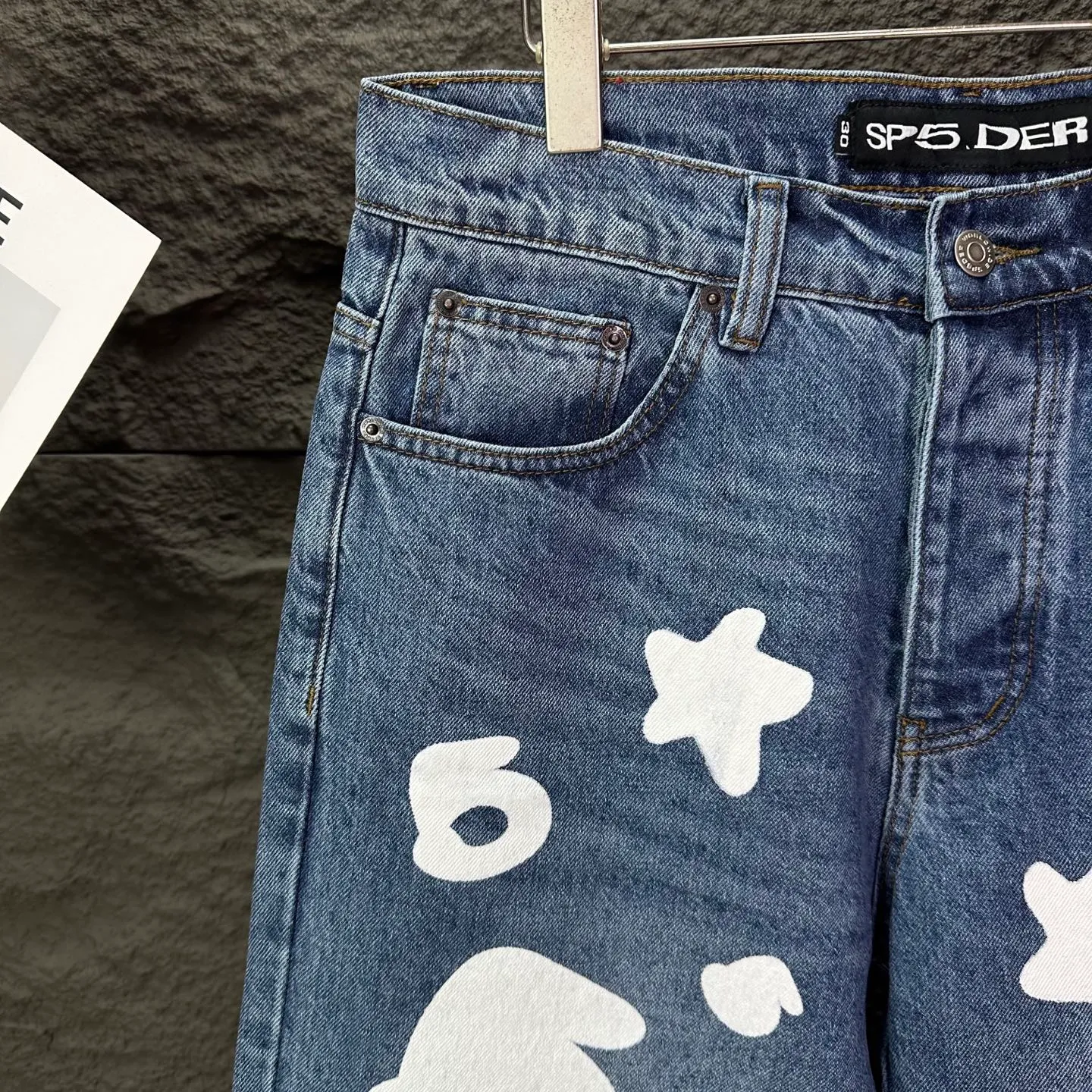 P240 Sp10der street fashion brand 2025 new white big star printed washed and distressed couple style loose straight jeans 🔥High version🔥High version🔥 Top ceiling quality Styles with different washed textures are very friendly to people with thin legs and thick legs. The straight and loose version is very flattering. Moderate length that never goes out of style, easy to match with casually, basic styling for various styles, a must-have in the wardrobe! The fabric is stiff but also makes the upper body soft without losing texture. The washing process is even more perfect. It is a must-have item for everyone! ! ! Washed wheat, hang tag, pants label, three complete labels, color: blue, size: 28, 30, 32, 34, 36 (five sizes)