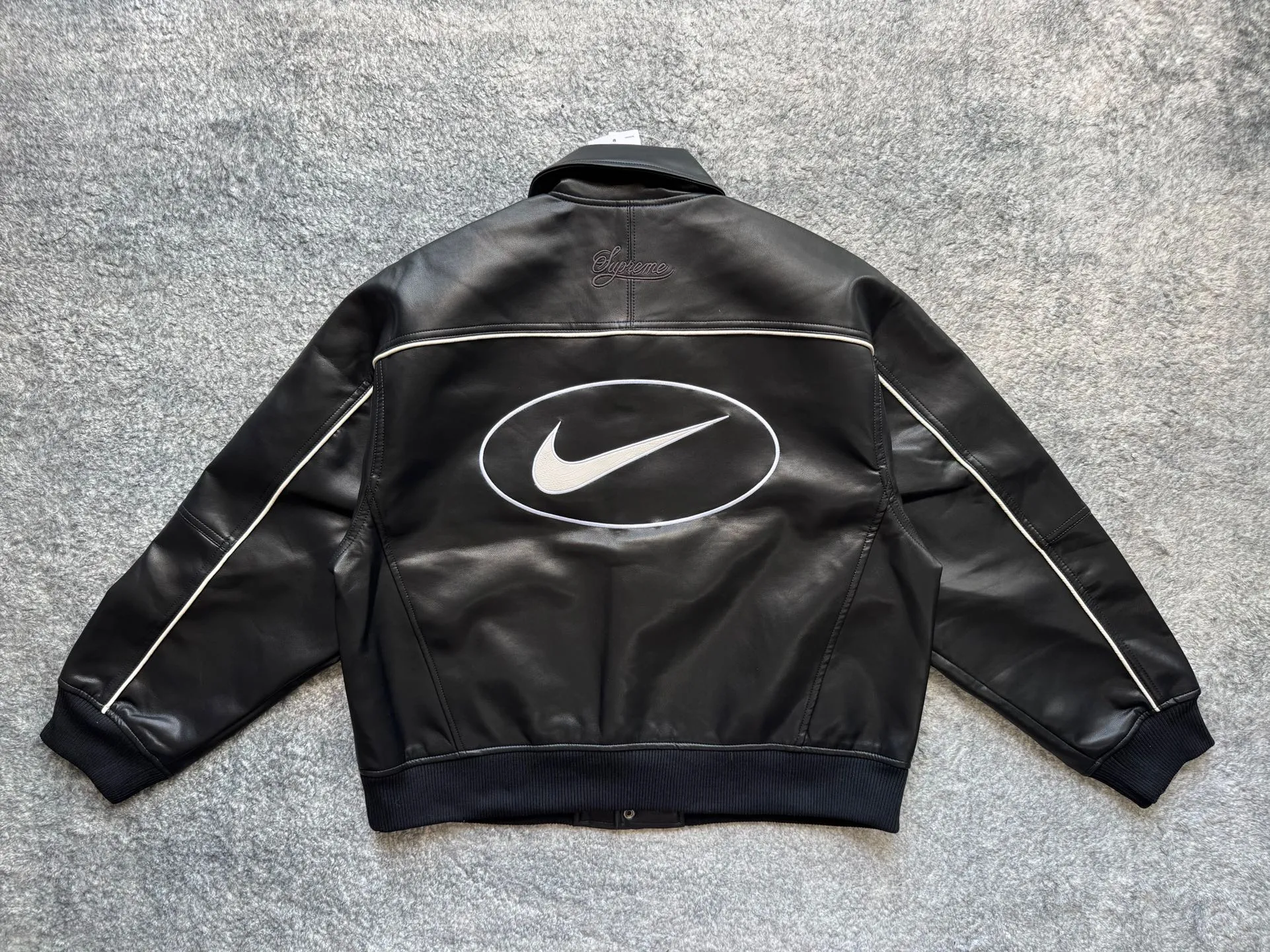 P540 [First release on the whole network, top version] Supreme xNike joint model SS25 WEEK4 Leather Varsity Jacket Back logo leather varsity jacket, same style for men and women. The fabric is made of original 1:1 fabric, and the original customized lining is made of ‌Var Satin‌ fabric: it has enough elasticity and drape, strong gloss, and is not easy to wrinkle. Breathability is good. Color: Black, White Size: S-XL Length Bust Sleeve Length S 64 128 72 M 66 132 74 L 68 136 76.5 XL 70 140 79