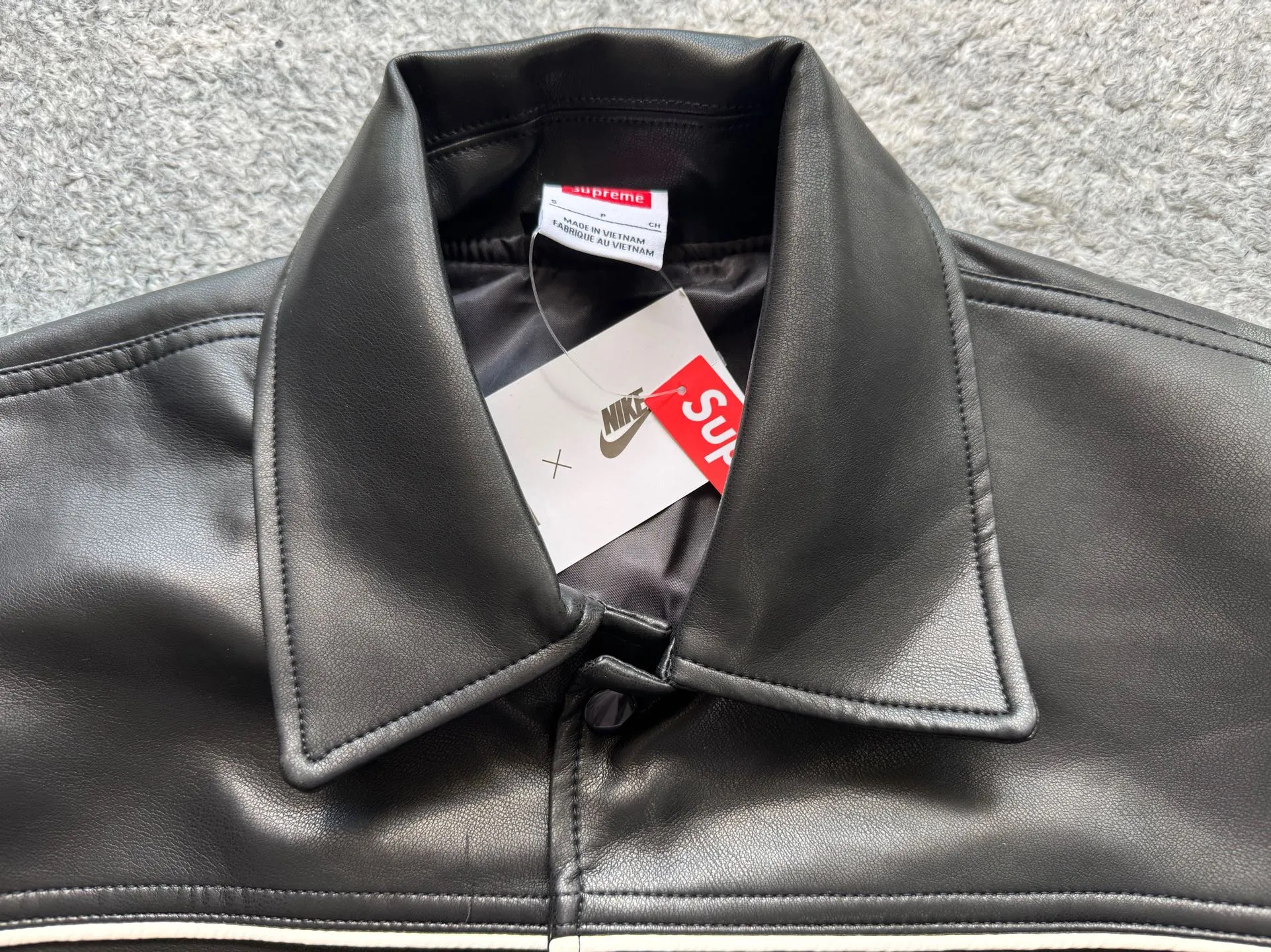 P540 [First release on the whole network, top version] Supreme xNike joint model SS25 WEEK4 Leather Varsity Jacket Back logo leather varsity jacket, same style for men and women. The fabric is made of original 1:1 fabric, and the original customized lining is made of ‌Var Satin‌ fabric: it has enough elasticity and drape, strong gloss, and is not easy to wrinkle. Breathability is good. Color: Black, White Size: S-XL Length Bust Sleeve Length S 64 128 72 M 66 132 74 L 68 136 76.5 XL 70 140 79
