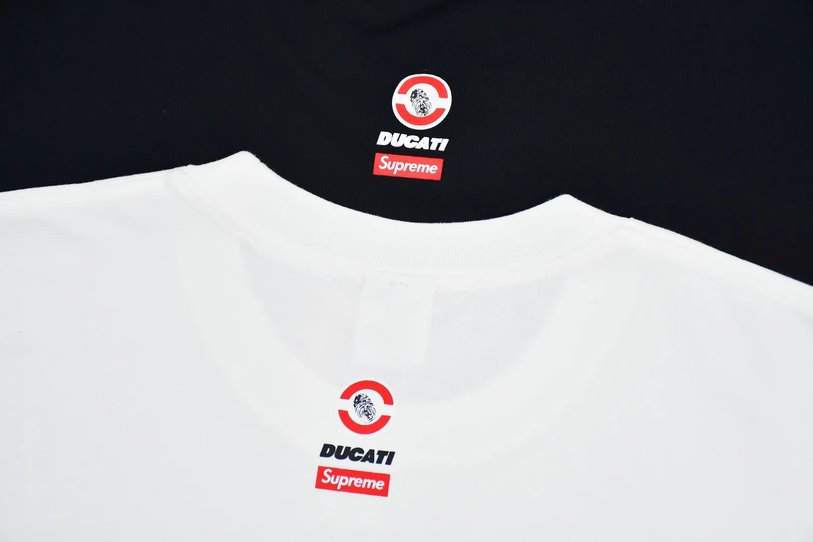 🅿️120 S168 top version Supreme 24ss DUCATI SS24 Ducati co-branded short-sleeved T-shirt. Refuse to look at pictures to make products. Refuse to compare with wrong versions. Use cylinder seamless technology (original technology. There are no stitched bones on the side of the clothes. Key points of identification) The fabrics are all custom-woven and dyed, 280g weight, 100% cotton, cylindrical fabric. Cylindrical fabric is a knitted fabric woven with a cylinder loom. The needles are distributed in a cylindrical shape on the fuselage. The gray fabric is a large cylinder, which needs to be opened and shaped before it can be used further. There are no slits on the side of the clothes, so there is no washing label on the side of ordinary short-sleeves. There is only one collar label behind the neck. The printing uses thermosetting ink printing imported from Belgium (different from conventional thermal transfer printing), also known as plastic ink, or self-adhesive ink. Its ingredients are: mainly composed of polyvinyl chloride (PVC) and phthalates. PVC and phthalates, solid color The thermoset ink is composed of a mixture of agents, stabilizers, and thickeners. It is not the digital direct printing advertised on the market. The printing texture of thermoset ink cannot be achieved by digital direct printing. The collar label has a watermark anti-counterfeiting effect, a real anti-counterfeiting layer, a version with a high probability of passing the inspection, and a high probability of passing the original packaging picture. Size：S-XL