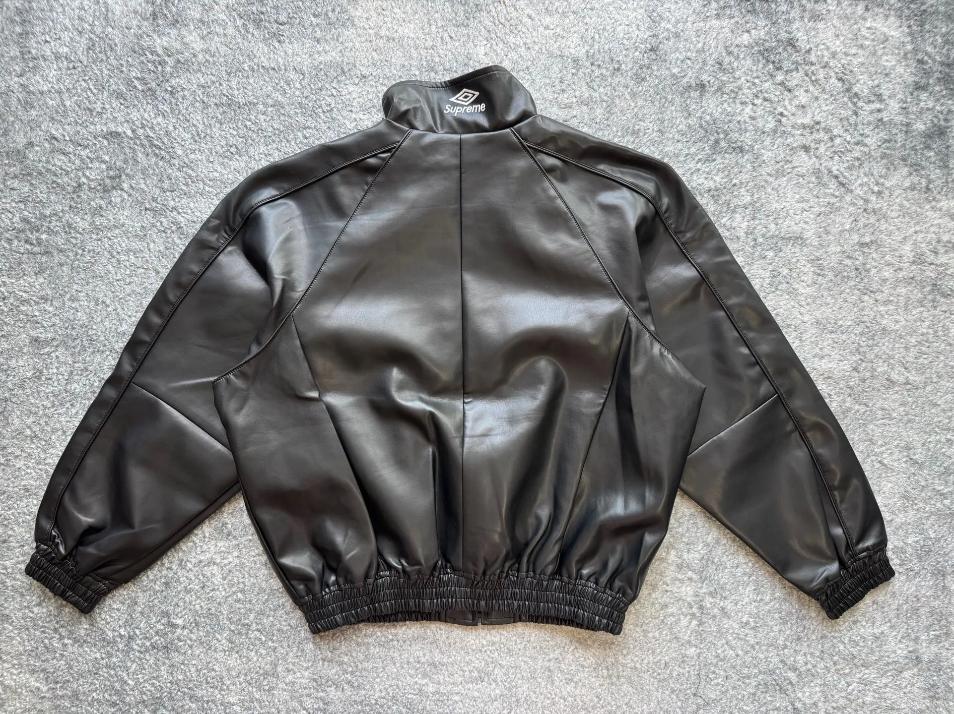 P590 Supreme Umbro joint model FW25 WEEK4 Leather Track Jacket embroidered logo zipper closure leather jacket, same style for men and women, made of lambskin material, mesh lining. Welted zippered hand pockets at lower front and internal chest pocket. Elasticized cuffs and hem in leather. Embroidered logo at chest and back neck. Color: Black, Navy, Pink Size: S M L
