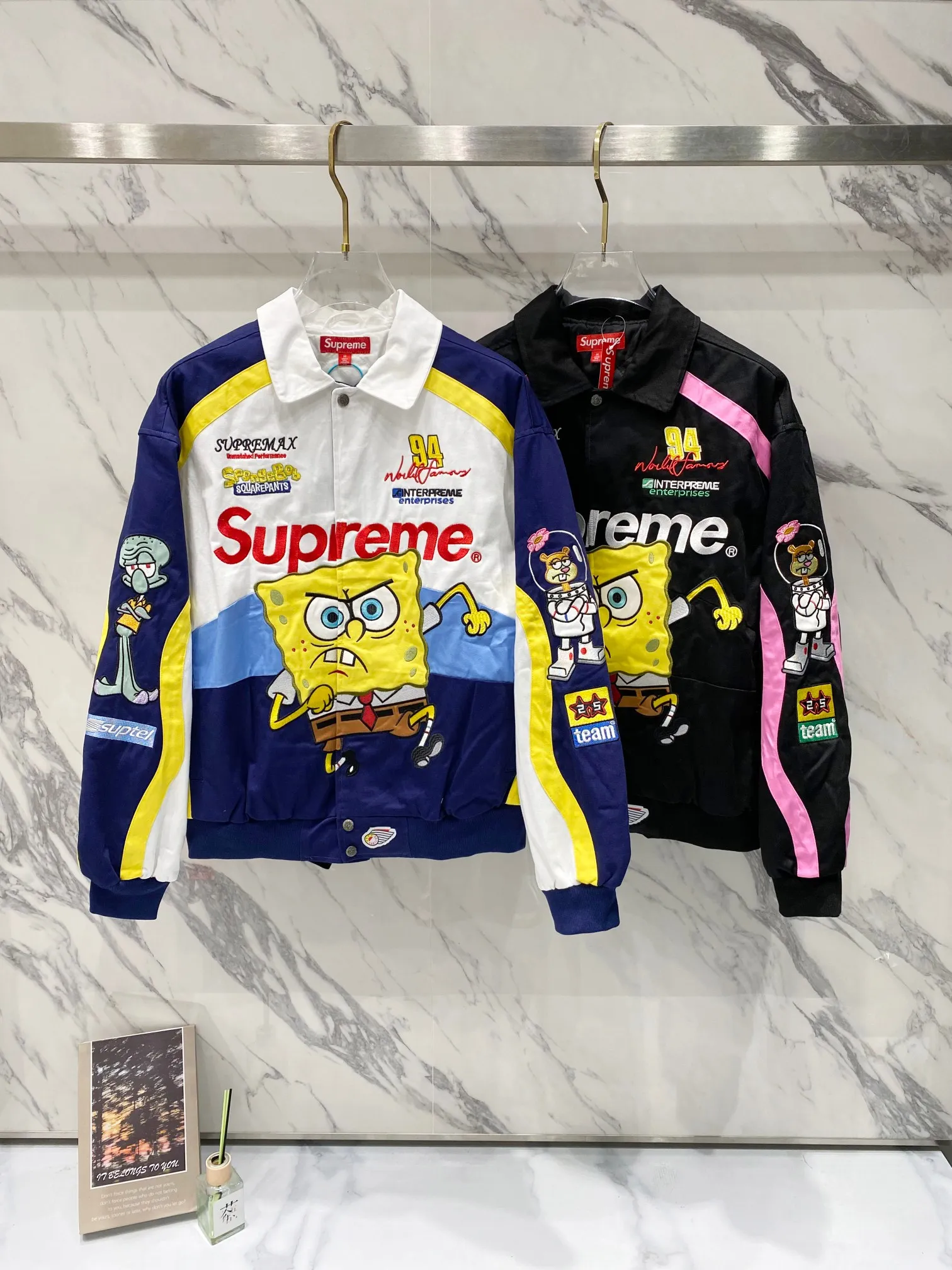 P760 Supreme SpongeBob SquarePants x JEFF HAMILTON joint model SS WEEK11 cartoon print pattern embroidered logo racing American trendy jacket, same style for men and women. A popular item in the trend circle is coming. Three-party masterpiece jackets are launched. When the street king Sup meets the childhood top SpongeBob SquarePants, when Jeff Hamilton's heavy machine embroidery hits the Beach Castle, everyone goes berserk. This jacket has become a mobile trend temple, and the wonderful chemical reaction is full instantly. Pink and black contrasting racing genes, blue, white and yellow collide to create sparks of vitality. Spongebob's angry and funny look is very personalized. Sandy and Squidward are "assist" by the side. Every pattern hides memories. This is not a simple jacket, but a work of art intertwined with trends and emotions. Wear it, walk out your own cool steps, and easily capture the attention of everyone! If you are trendy, don’t miss this co-branded jacket. Original development. Complete accessories. Exquisite workmanship. The quality is as good as ever. Color: black white. Size: S M L XL size: length 76, bust 148, shoulder width 62