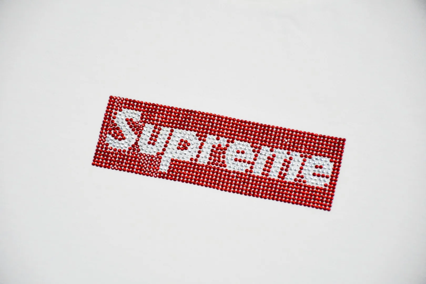 S106💰p130 Top version Supreme Swarovski Box Logo Tee 25th Anniversary Swarovski short-sleeved T-shirt 1. Using cylindrical seamless technology (the original technology has no gaps on the sides of the clothes) The fabrics are all custom-woven and dyed, 280g weight, 100% cotton, cylindrical fabric. The cylindrical fabric is a knitted fabric woven with a cylinder loom. The needles are distributed in a cylindrical shape on the fuselage. The gray fabric is a large cylinder, which needs to be opened and shaped before it can be used further. There is no slit on the side of the clothes, so there is no washing label on the side of ordinary short-sleeves. There is only one collar label behind the neck. 2. Hot rhinestones. The number, size and alignment are all consistent with YB. The machine adopts German ultrasonic hot drilling machine or hot sheet welding machine. Its principle is to use the ultrasonic host to output ultrasonic piezoelectric signals, convert the ultrasonic piezoelectric signals into mechanical energy through the piezoelectric transducer, and then push the workpiece to rub against the pasting surface at high speed. The heat generated by the friction of the workpiece quickly melts the rubber on the contact surface and combines them into one, thereby achieving the purpose of pasting. Since the pasting accessories are directly fused with the bonding surface, the pasting structure is very strong and is not easy to come off. 3. The collar label has a watermark anti-counterfeiting effect, a real anti-counterfeiting layer, and has a high probability of passing the inspection version, and the original packaging picture has a high probability of passing. 4. Equipped with YB packaging bag, handbag, color: black and white, size: S~XL