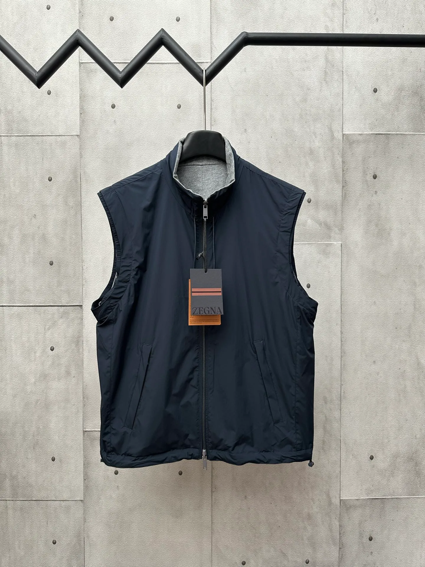 🅿️650 ZEGNA microfiber double-sided Brezza vest Fabric selection: Microfiber fabric made of 100% polyester fiber is famous for its excellent tear resistance and wear resistance. It can quickly return to flatness during wearing and maintain the crisp and stylish appearance of the clothing for a long time. At the same time, it is not easy to deform after long-term washing, ensuring dimensional stability. After being waterproofed, it can be adapted to various weather wearing needs.  Fabric on the other side: Cashmere blended jersey fabric. The diameter of cashmere fiber is only 14 microns. After blending, it eliminates the itch of pure cashmere. The central control structure locks in still air and has strong warmth retention. A small amount of nylon enhances the durability of cashmere and extends its service life.  Technology: The monochrome letter LOGO on the cashmere blended surface controls the collaborative operation of the machine head, needle bar, and bobbin through the high-precision calculation system of the computer embroidery machine. The fabric frame moves accurately in the horizontal and vertical directions to form a stitch track, and the upper and lower thread tensions are adjusted to ensure that the stitches are smooth and free of floating lines, forming a fine letter pattern with an error of ±0.1mm. Accessories: One-to-one customized neck drawstring head, One-to-one customized hem drawstring buckle, One-to-one customized zipper puller SIZE: 46 48 50 52