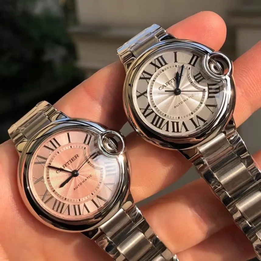 The steel strap model comes first. The all-stainless steel case and strap have pink and white dials. Ballon Bleu de Cartier Cartier blue balloon watch, 33 mm model, self-winding mechanical movement. Stainless steel case, fluted crown set with a cabochon of synthetic spinel. Silver-plated guilloché dial. Sword-shaped blued steel hands. Sapphire crystal mirror. Interchangeable stainless steel bracelet. Thickness: 9.96mm. Water-resistant to 3 bar (approximately 30 meters).